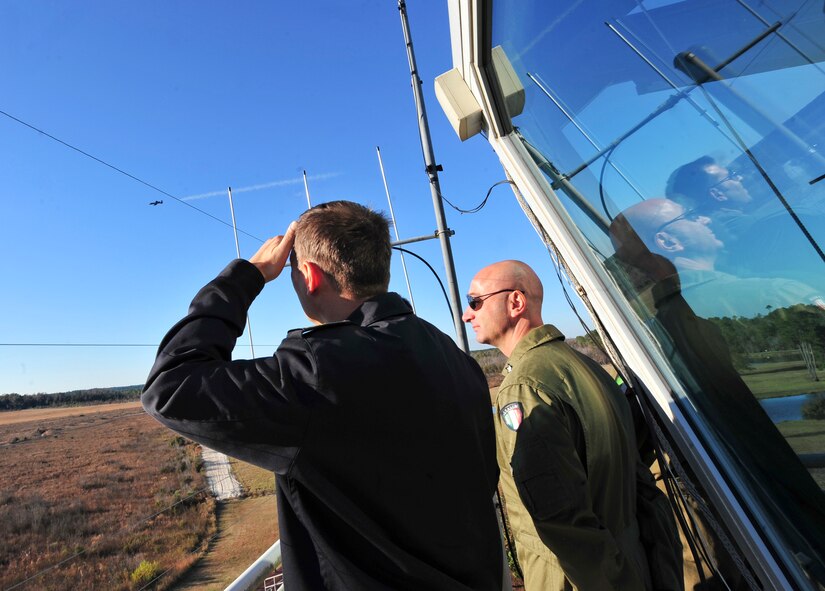 Italian air force Colonnello (Col.) Flavio Danielis, air attaché to the Italian embassy in D.C. and Tenente Colonnello (Lt. Col.) Michele Ciuffreda, watch strafing capabilities of an A-10C Thunderbolt II over Grand Bay Bombing and Gunnery Range at Moody Air Force, Ga., Dec. 1, 2011. This was their first time visiting Moody and they got to see the A-10 capabilities up close. (U.S. Air Force photo by Staff Sgt. Stephanie Mancha/Released)
