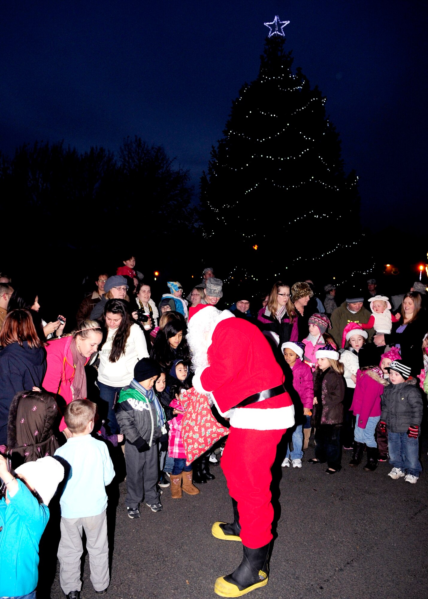 RAF MILDENHALL, England – Santa Claus hands out candy to children during his surprise visit at the annual Christmas Tree Lighting Ceremony here Dec. 2, 2011. The ceremony celebrated the start of the Christmas season for RAF Mildenhall. (U.S. Air Force photo/Senior Airman Ethan Morgan)