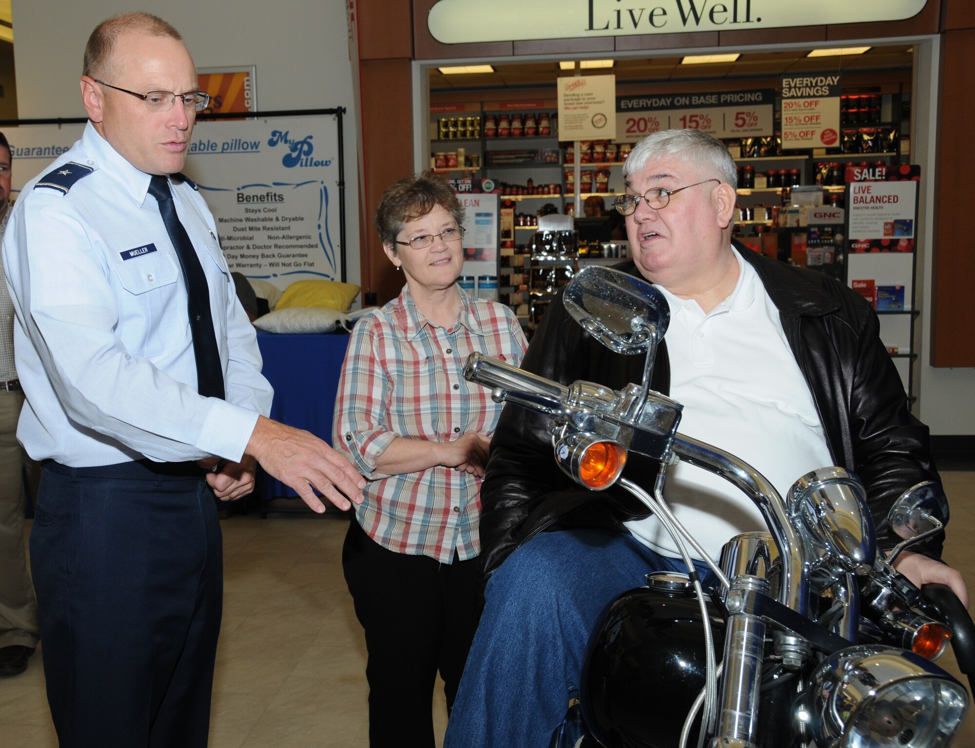 Brig. Gen. Andrew Mueller, 81st Training Wing commander, congratulates Sandra and Army retiree Norbert Gaul from Saucier, on winning a Harley Davidson motorcycle Dec. 1, 2011, at the base exchange at Keesler Air Force Base, Miss. They won the motorcycle in the Army and Air Force Exchange Service’s 7-Up Captain America sweepstakes.  (U.S. Air Force photo by Kemberly Groue)