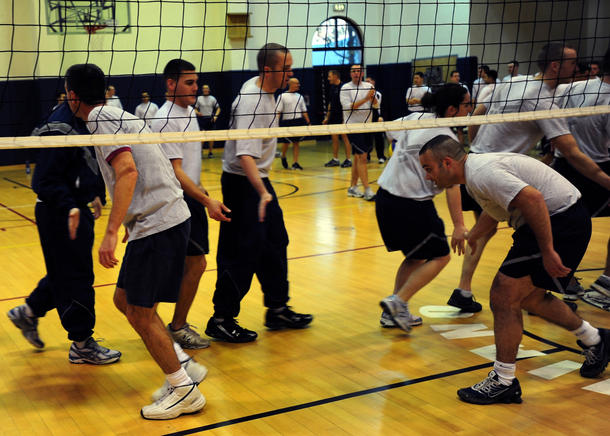 Airman Leadership School class 12B slap hands with commanders to end the game Dec.1 at Aviano Air Base, Italy. ALS class 12B and commanders show good sportmanship at the end of the traditional ALS versus commanders volleyball game, in which ALS class 12B was defeated. (U.S. Air Force photo/Airman 1st Class Jenay Randolph)
