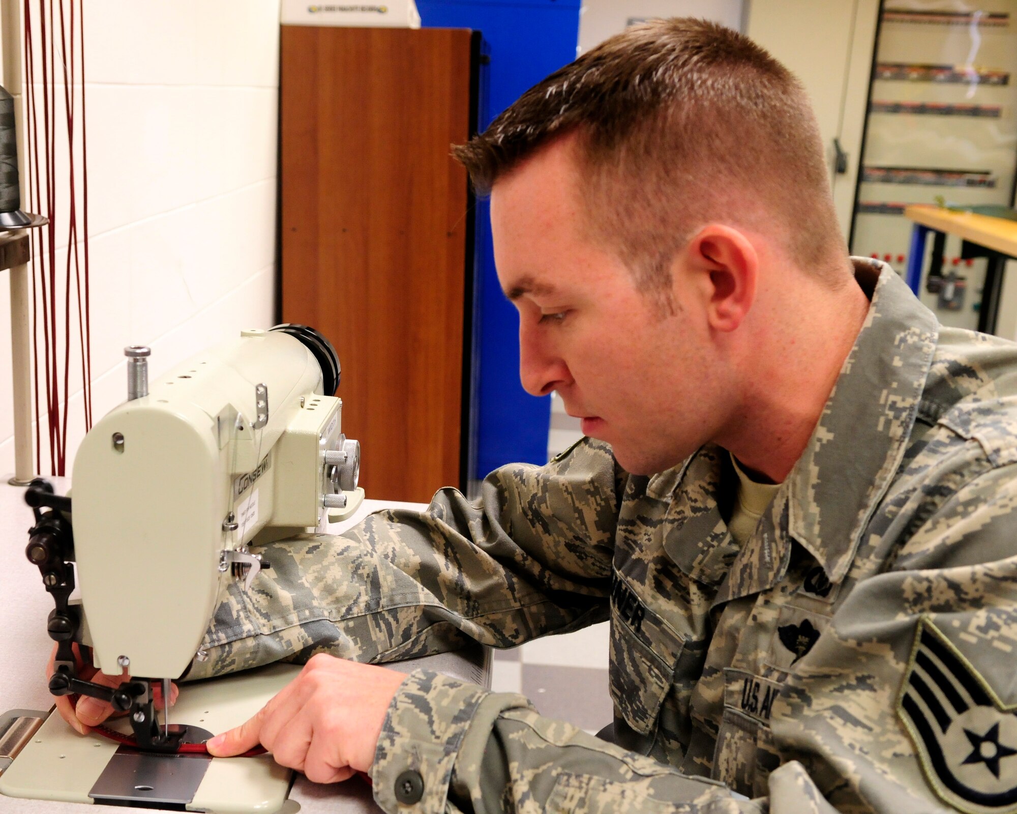 Staff Sgt. Jacoby Bruner, 31st Operations Support Squadron aircraft fuel tanks equipment craftsman, fabricates a new handle for a recovery parachute Nov. 30 at Aviano Air Base, Italy. The handle helps aircrew members maneuver the parachute during an ejection. (U.S. Air Force photo/Airman 1st Class Briana Jones)