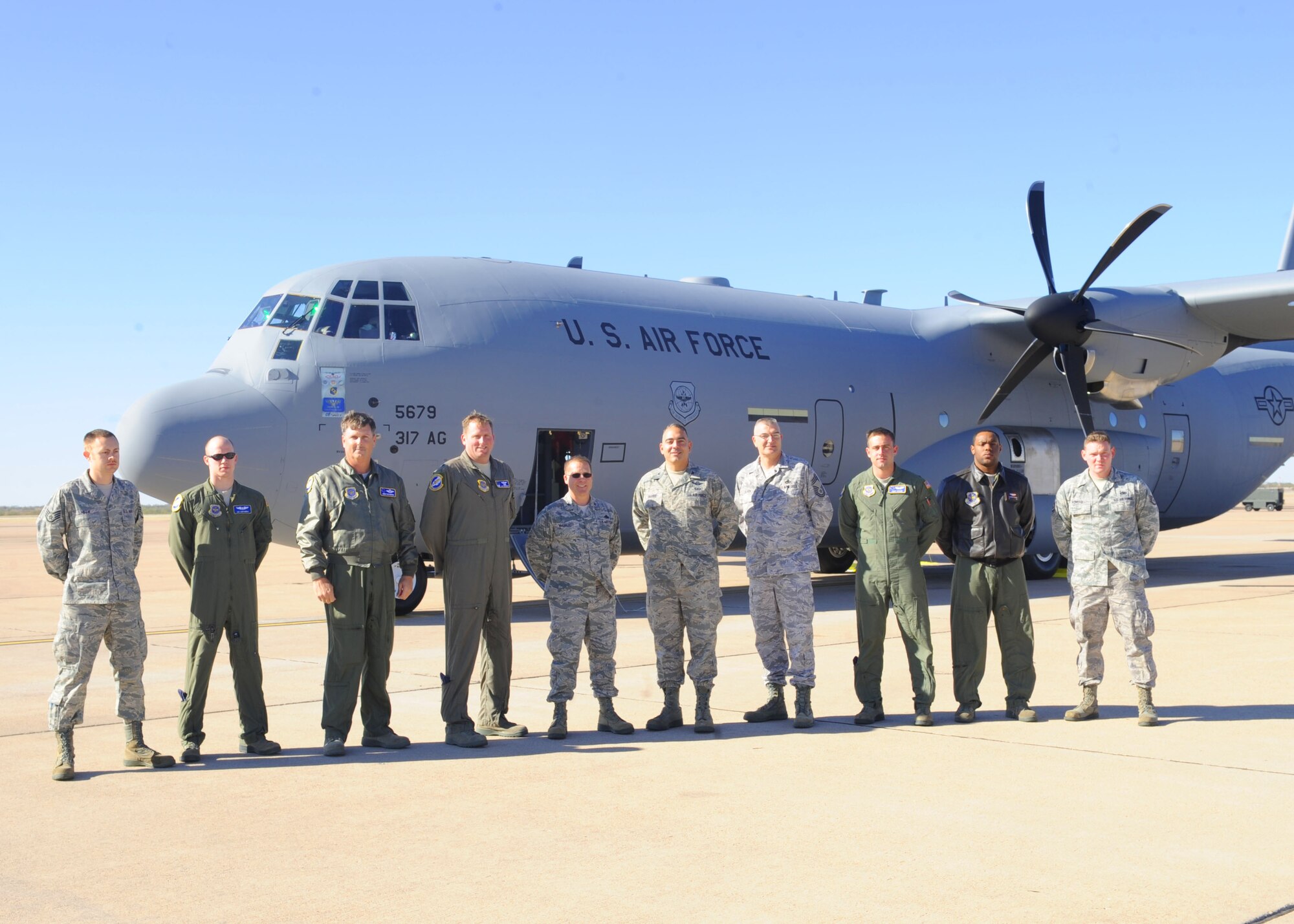 The crew of a new C-130 J-model gathers outside the aircraft Nov. 30, 2011, at Dyess Air Force Base, Texas. The aircraft is the 12th of 28 to be delivered to Dyess by 2013, replacing the current aging fleet of the C-130 Hercules. (U.S. Air Force photo by Airman 1st Class Cierra Bullock/Released)