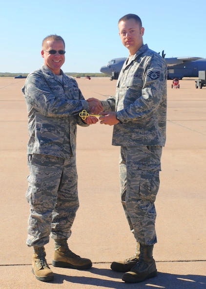 Col. Todd McCready, 7th Maintenance Group commander, presents the honorary key to Staff Sgt. Michael Smith, 7 AMXS, on behalf of Staff Sgt. Jaime Febus, 7 AMXS, Nov. 30, 2011, at Dyess Air Force Base, Texas. The aircraft is the 12th of 28 to be delivered to Dyess by 2013, replacing the current aging fleet of the C-130 Hercules. (U.S. Air Force photo by Airman 1st Class Cierra Bullock/Released)