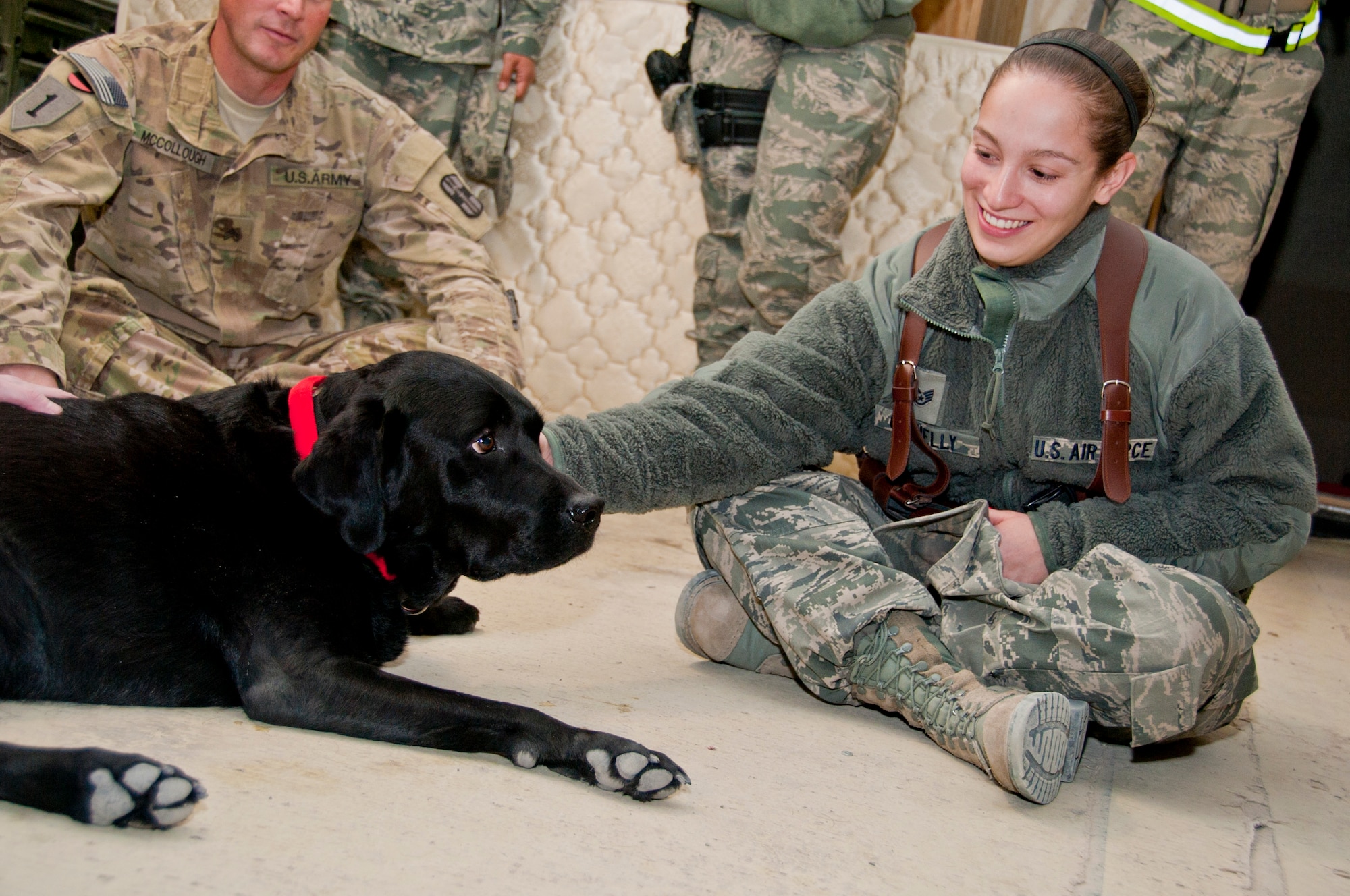 KANDAHAR AIRFIELD, Afghanistan -- Staff Sgt. Jennifer Connelly, 451st Air Expeditionary Wing Protocol office, lays next to Sgt. 1st Class Zeke, a combat stress dog from Kandahar Airfield's Role 2, Dec. 1, 2011. As a combat stress dog, Zeke and his handler, Army Sgt. Paul McCollough, visit patients at Role 3 and requesting units around KAF to increase morale and welfare. (U.S. Air Force photo by Staff Sgt. David Carbajal)