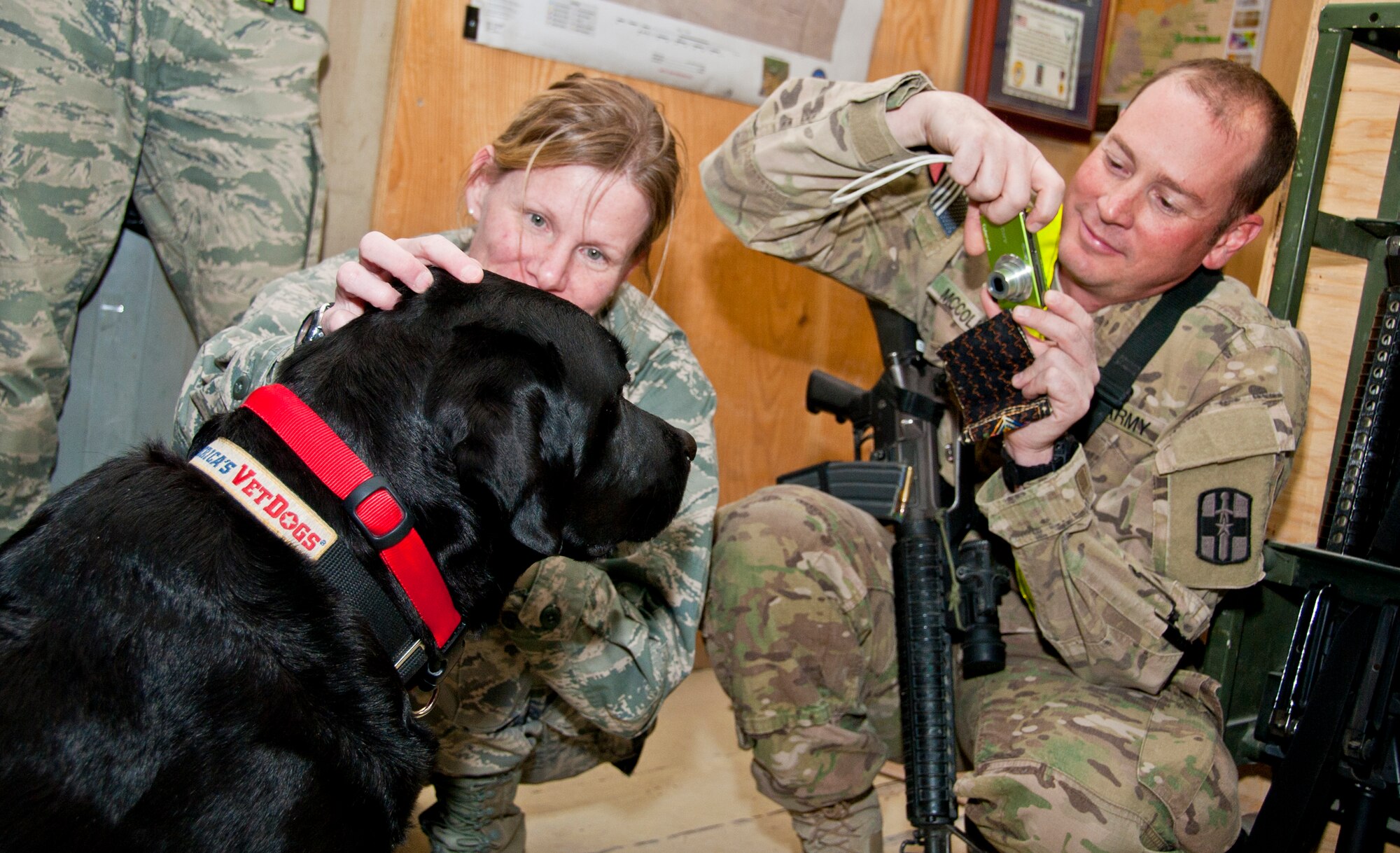 KANDAHAR AIRFIELD, Afghanistan -- Maj. Danielle Folsom (left), 73rd Expeditionary Air Control Squadron commander, pets Sgt. 1st Class Zeke, a combat stress dog from Kandahar Airfield's Role 2, Dec. 1, 2011. As a combat stress dog, Zeke and his handler Army Sgt. Paul McCollough (right) visit patients at Role 3 and requesting units around KAF to increase morale and welfare. (U.S. Air Force photo by Staff Sgt. David Carbajal)