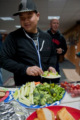 Senior Airman Timothy Place, 39th Security Forces Squadron base defense operations center controller, fills a plate with vegetables during a free Airman's dinner at The Connection Dec. 1, 2011, at Incirlik Air Base, Turkey.  The Connection, a building and program run by the 39th Air Base Wing Chapel, provides unaccompanied Airmen sanctuary from the hectic bustle outside the building’s walls. (U.S. Air Force photo by Senior Airman Anthony Sanchelli/Released)
