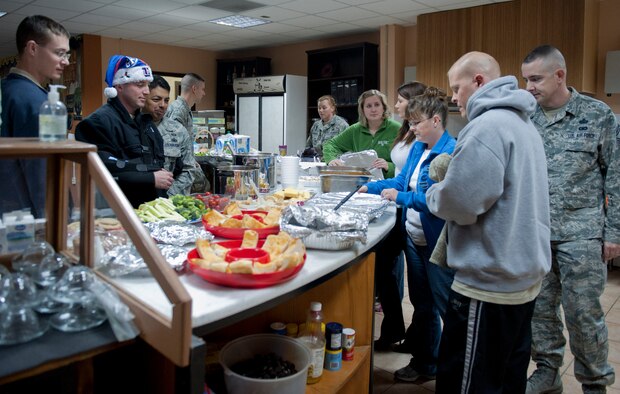 Members of the 39th Security Forces Squadron set up an assortment of food for a free Airman's dinner at The Connection Dec. 1, 2011, at Incirlik Air Base, Turkey.  The Connection, a building and program run by the 39th Air Base Wing Chapel, provides unaccompanied Airmen sanctuary from the hectic bustle outside the building’s walls. (U.S. Air Force photo by Senior Airman Anthony Sanchelli/Released)
