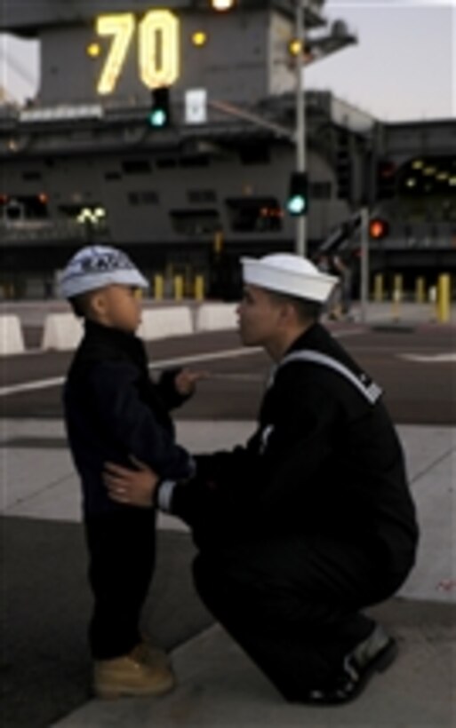 U.S. Navy Petty Officer 3rd Class Teejay Sunglao says goodbye to his son before the aircraft carrier USS Carl Vinson (CVN 70) departs Naval Air Station North Island for a western Pacific deployment in Coronado, Calif, on Nov. 30, 2011.  