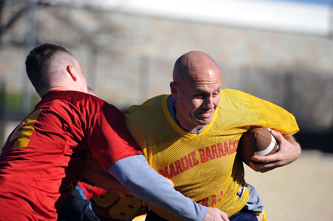 Capt. Eric Dwyer, Team CO, collides with Capt. John Norton, Team XO, during the first half of the 2011 Oyster Bowl at Marine Barracks Washington Dec. 2. The Oyster Bowl is a yearly flag-football faceoff between the Barracks commanding officer’s team, yellow, and the executive officer’s team, red. The XO’s team shut out the CO’s team with 18 points.