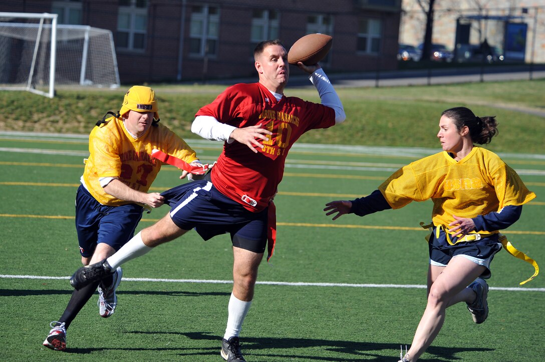 Capt. William Smith and Capt. Stephanie Drake, Team CO, attempt to sack Maj. Thomas Shields, Team XO quarterback, as he throws the ball during the second half of the 2011 Oyster Bowl at Marine Barracks Washington Dec. 2. The Oyster Bowl is a yearly flag-football faceoff between the Barracks commanding officer’s team, yellow, and the executive officer’s team, red. The XO’s team shut out the CO’s team with 18 points.::r::::n::