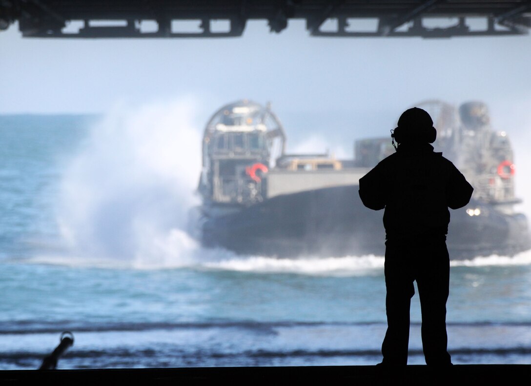 A Landing Craft Air Cushioned Hovercraft (LCAC) transport Marines and tactical vehicles with the 24th Marine Expeditionary Unit aboard the USS Iwo Jima (LHD 7) off the coast of Camp Lejeune, Nov. 30, 2011. The MEU is currently taking part in Composite Unit Training Exercise (COMPTUEX), scheduled to take place Nov. 28 to Dec. 21. The training is meant to develop cohesion between the MEU and Amphibious Squadron 8 (PHIBRON-8) in conducting amphibious operations, crisis response, and limited contingency operations while operating from the sea.