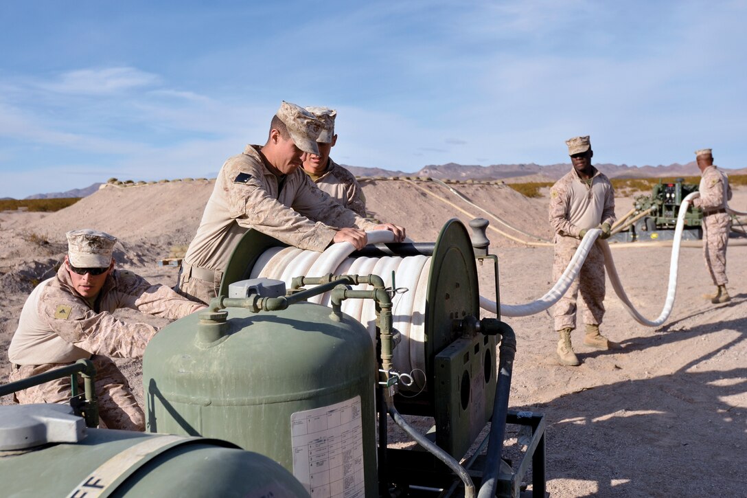 Marines with Engineer Company retract a fire hose after an immediate action drill at Marine Air Ground Combat Center Twentynine Palms, Calif., Dec. 2, where they responded to a simulated fire in one of the fuel reservoirs on a forward fuel farm they established during Enhanced Mojave Viper. In the event of a real incident, the Marines would be called upon to contain and extinguish the fire before it jeopardizes the functionality of the fuel farm. Engineer Co. is attached to Combat Logistics Batalion 4, Combat Logistics Regiment 3, 3rd Marine Logistics Group, III Marine Expeditionary Force.