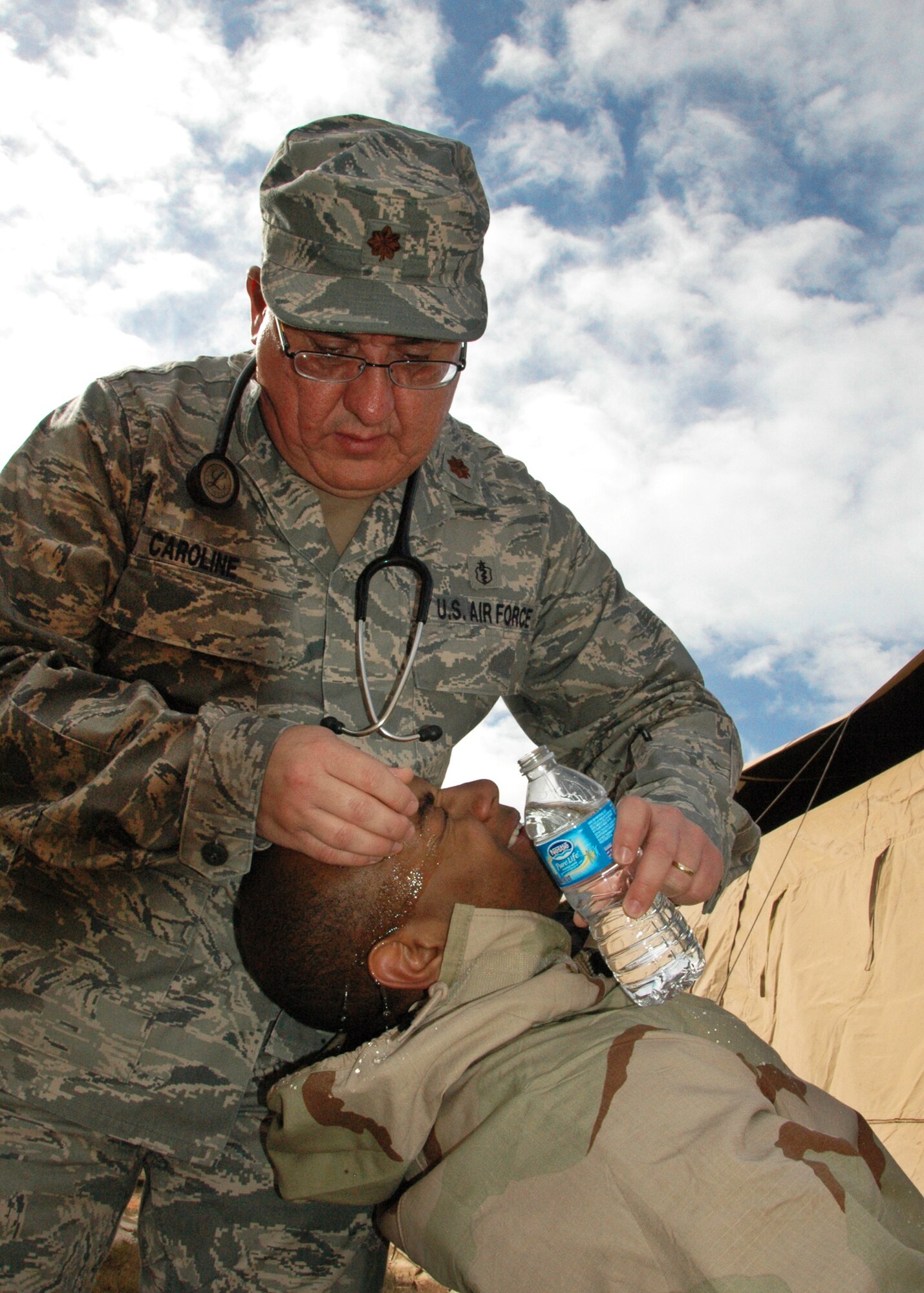 Major (Dr.)  John Caroline of the 919th Medical Squadron rinses debris from the eyes of Airman 1st Class Christopher Barthe, a member of the 556th RED HORSE Squadron, during the latter unit’s  recent field exercise at Eglin Air Force Base Field 5, Fla.   The RHS exercise afforded the medics an opportunity to both train and offer real world treatment, including routine immunizations, to the Duke Field-supported and Hurlburt Field-based Reserve combat civil engineer unit.  (U.S. Air Force photo/Staff Sgt. Jonathan McCallum)