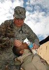 Major (Dr.)  John Caroline of the 919th Medical Squadron rinses debris from the eyes of Airman 1st Class Christopher Barthe, a member of the 556th RED HORSE Squadron, during the latter unit’s  recent field exercise at Eglin Air Force Base Field 5, Fla.   The RHS exercise afforded the medics an opportunity to both train and offer real world treatment, including routine immunizations, to the Duke Field-supported and Hurlburt Field-based Reserve combat civil engineer unit.  (U.S. Air Force photo/Staff Sgt. Jonathan McCallum)