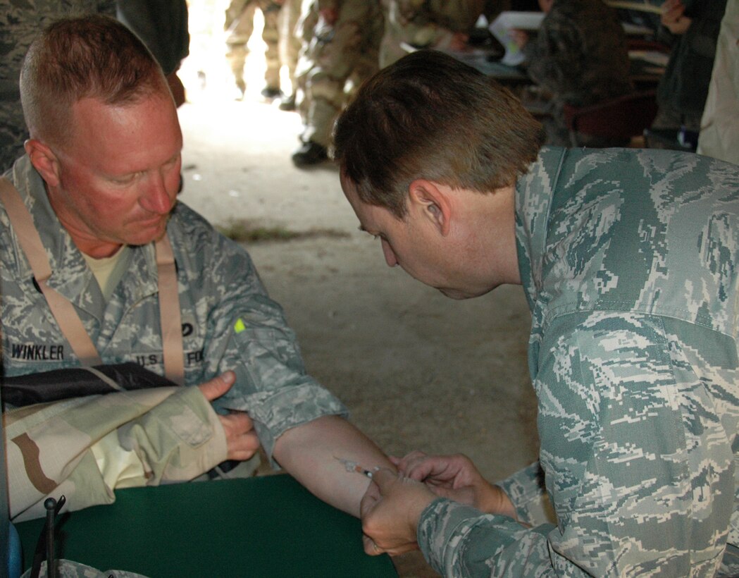 Major Michael Hinton, a 919th Medical Squadron critical care nurse, administers a TB test for Master Sgt. Robert Winkler of the 556th RED HORSE Squadron during the latter unit’s recent field exercise at Eglin Air Force Base Field 5, Fla.   The RHS exercise afforded the medics an opportunity to both train and offer real world treatment, including routine immunizations, to the Duke Field-supported and Hurlburt Field-based Reserve combat civil engineer unit.  (U.S. Air Force photo/Staff Sgt. Jonathan McCallum)