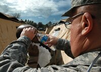 Major (Dr.)  John Caroline of the 919th Medical Squadron rinses debris from the eyes of  Airman 1st Class Christopher Barthe, a member of the 556th RED HORSE Squadron, during the latter unit’s  recent field exercise at Eglin Air Force Base Field 5, Fla.   The RHS exercise gave the medics an opportunity to both train and offer real world treatment, including routine immunizations, to the Duke Field-supported and Hurlburt Field-based Reserve combat civil engineer unit.  (U.S. Air Force photo/Staff Sgt. Jonathan McCallum)