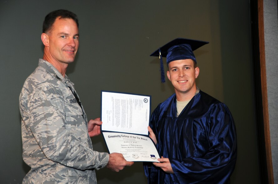 Col. Eric Overturf, 442nd FIghter Wing commander, presents reservists with their Community College of the Air Force Associate's Degree, Dec. 3. Ten reservists from the 442nd Fighter Wing participated in the graduation ceremony where they received their degrees. The ceremony was hosted by the 442nd Training and Education office. The 442nd Fighter Wing is an A-10 Thunderbolt II Air Force Reserve unit at Whiteman Air Force Base, Mo. (U.S. Air Force photo/Staff Sgt. Danielle Wolf)