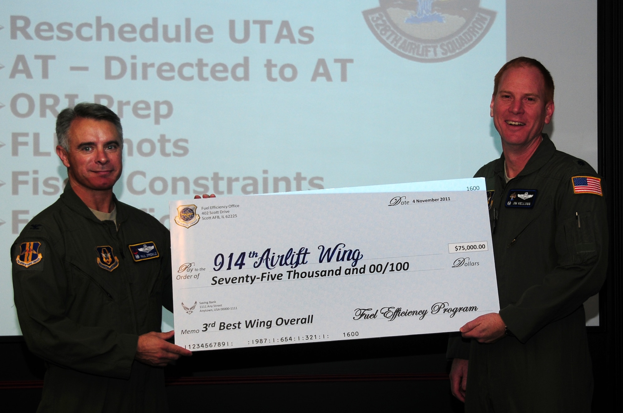 914th Operations Group Commander Col. Paul Sprenkle and 328th Airlift Squadron Commander Lt. Col. James Kellogg hold the check they received from the Fuel Efficiency Office. Through dilligent planning and execution, the 914th and 107th Airlift Wings correctly utilized technology married up with environmental conditions for reducing their need for fuel. (U.S. Air Force photo by Senior Airman Jessica Mae Snow)

