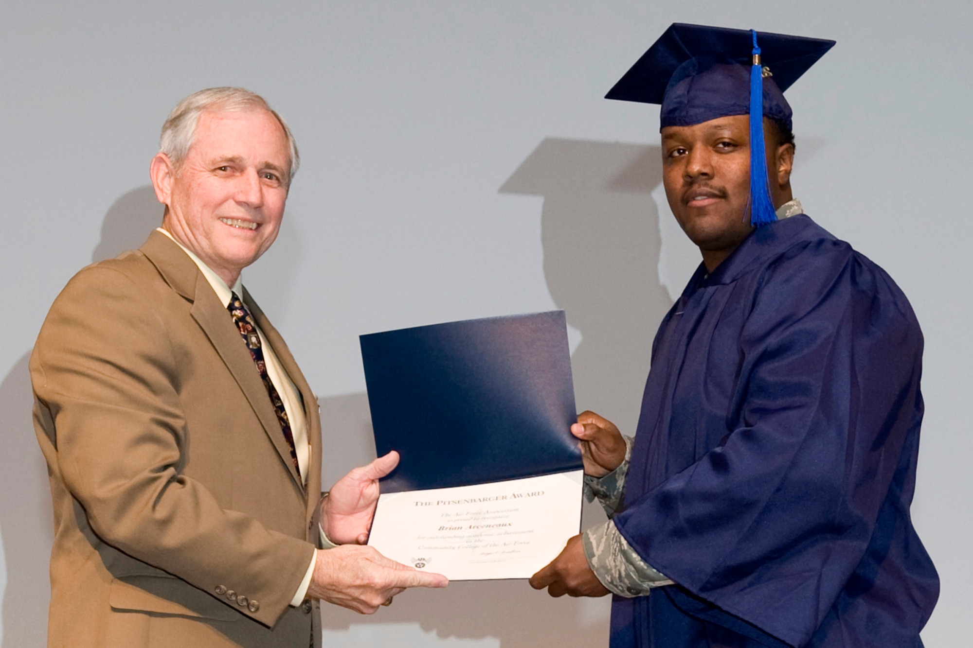 Chief Master Sgt. (Ret) Jack Skaggs presents Brian S. Arceneaux the Pitsenbarger Award for the Reserves during Community College of the Air Force graduation ceremonies in Hoban Hall at Barksdale Air Force Base, La., Nov. 30, 2011.  Arceneaux is also a Technical Sergeant in the Air Force Reserve and is assigned to the 307th RED HORSE Squadron at Barksdale. The award is named for Airman First Class William H. Pitsenbarger, a Pararescueman, who unselfishly gave his life trying to save casualties near Saigon April 11, 1966, at the young age of 21. Arceneaux also received his Associate in Applied Science Restaurant, Hotel & Fitness Management degree during the ceremonies. More than 30 Reserve Airmen at Barksdale achieved their CCAF diploma during this graduation cycle. (U.S. Air Force photo by Airman 1st Class Benjamin W. Gonsier/Released)  