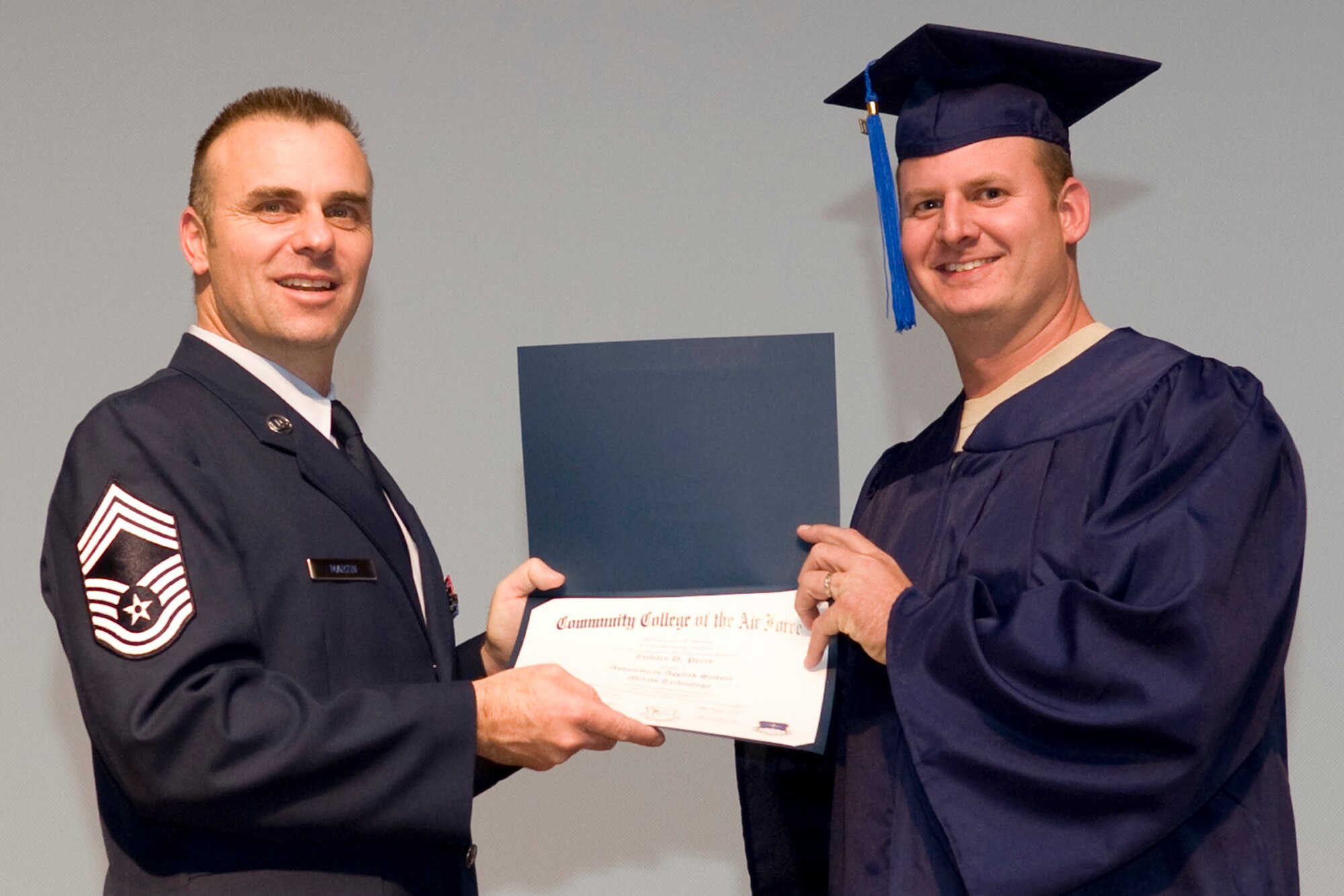 Chief Master Sgt. James G. Martin, aircraft systems superintendent, Air Force Global Strike Command, presents Zachary D. Perry his Associate in Applied Science Metals Technology degree during Community College of the Air Force graduation ceremonies in Hoban Hall at Barksdale Air Force Base, La., Nov. 30, 2011.  Perry is also a Technical Sergeant in the Air Force Reserve and is assigned to the 917th Maintenance Squadron at Barksdale. (U.S. Air Force photo by Airman 1st Class Benjamin W. Gonsier/Released)  