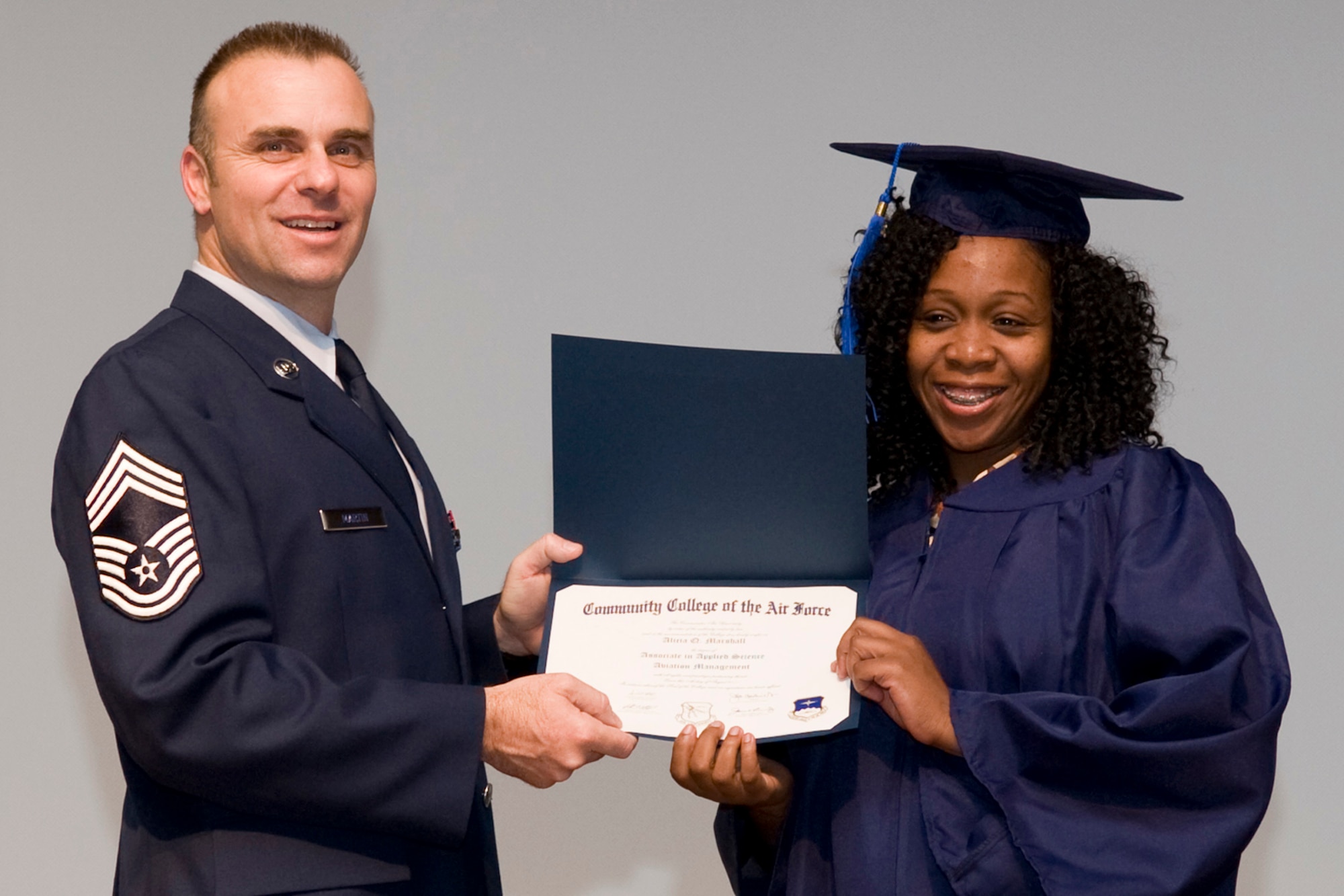 Chief Master Sgt. James G. Martin, aircraft systems superintendent, Air Force Global Strike Command, presents Alicia Q. Marshall her Associate in Applied Science Aviation Management degree during Community College of the Air Force graduation ceremonies in Hoban Hall at Barksdale Air Force Base, La., Nov. 30, 2011.  Marshall is also a Technical Sergeant with the Air Force Reserve and is assigned to the 93rd Bomb Squadron at Barksdale. (U.S. Air Force photo by Airman 1st Class Benjamin W. Gonsier/Released) 
