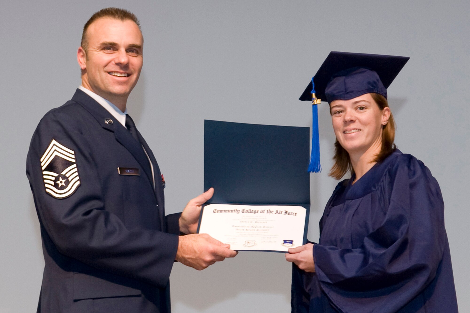 Chief Master Sgt. James G. Martin, aircraft systems superintendent, Air Force Global Strike Command, presents Debra C. Hancock her Associate in Applied Science Allied Health Sciences degree during Community College of the Air Force graduation ceremonies in Hoban Hall at Barksdale Air Force Base, La., Nov. 30, 2011.  Hancock is also a Technical Sergeant with the Air Force Reserve and is assigned to the 307th Medical Squadron at Barksdale. (U.S. Air Force photo by Airman 1st Class Benjamin W. Gonsier/Released)  