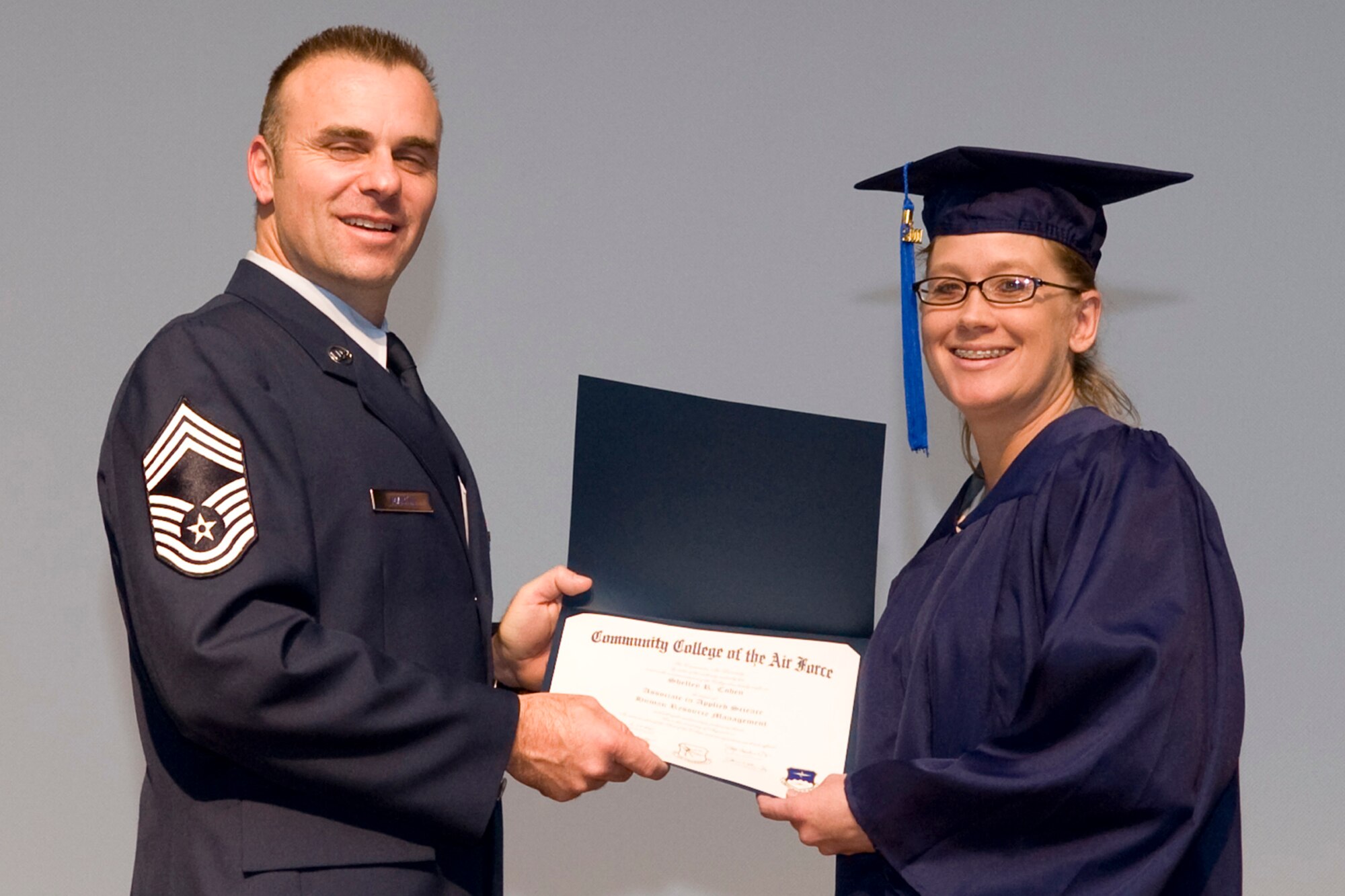 Chief Master Sgt. James G. Martin, aircraft systems superintendent, Air Force Global Strike Command, presents Shelley R. Cohen her Associate in Applied Science Human Resource Management degree during Community College of the Air Force graduation ceremonies in Hoban Hall at Barksdale Air Force Base, La., Nov. 30, 2011.  Cohen is also a Senior Master Sergeant with the Air Force Reserve and is assigned to the 307th RED HORSE Squadron at Barksdale. (U.S. Air Force photo by Airman 1st Class Benjamin W. Gonsier/Released)