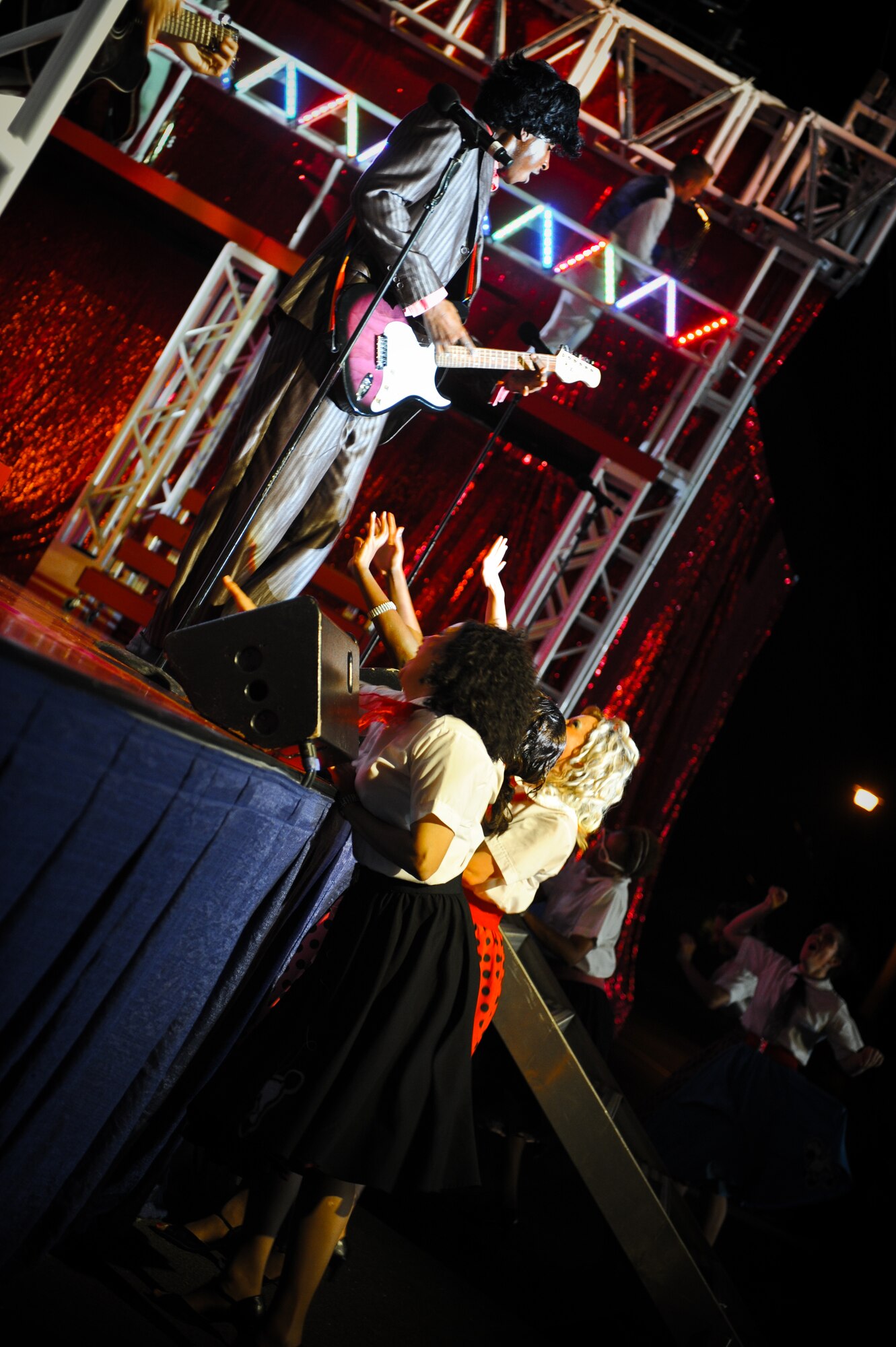 Entertainers from Tops in Blue perform the chart topping songs from each decade during a show at Freedom Tower on Joint Base Pearl Harbor-Hickam, Hawaii, Dec. 2. Before each performance, the Airmen of Tops in Blue unload and set up more than 80,000 pounds of equipment and use more than two miles of electrical cable. (U.S. Air Force Photo/Senior Airman Lauren Main) 