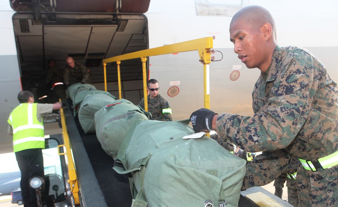 Marines of 1st Battalion, 4th Marine Regiment, from Camp Pendleton, Calif., unload baggage as they arrive to be the new Battalion Landing Team of the 31st Marine Expeditionary Unit, Dec. 4. The battalion is now the new ground combat element for the 31st MEU, and is scheduled to embark aboard ships of Amphibious Squadron 11 for support of Theater Security Cooperation in the Asia-Pacific region. The 31st MEU is America’s force in readiness in the Asia-Pacific region and the only continually forward-deployed MEU.