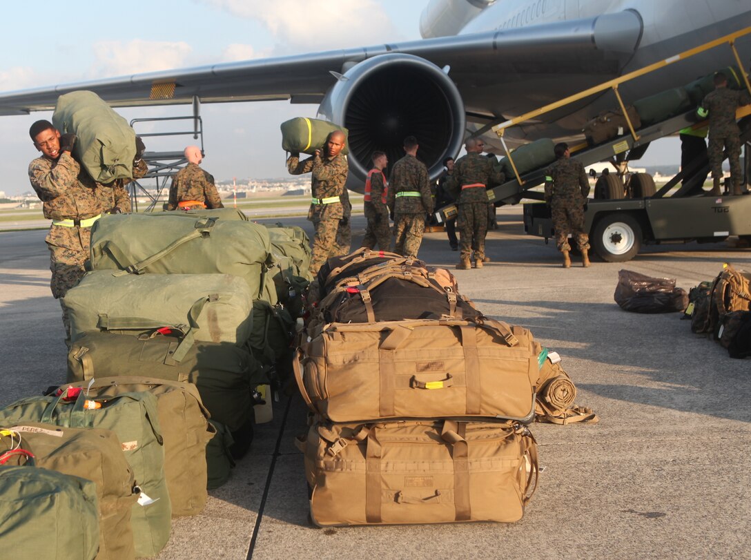 Marines of 1st Battalion, 4th Marine Regiment, from Camp Pendleton, Calif., unload baggage as they arrive to be the new Battalion Landing Team of the 31st Marine Expeditionary Unit, Dec. 4. The battalion is now the new ground combat element for the 31st MEU, and is scheduled to embark aboard ships of Amphibious Squadron 11 for support of Theater Security Cooperation in the Asia-Pacific region. The 31st MEU is America’s force in readiness in the Asia-Pacific region and the only continually forward-deployed MEU.