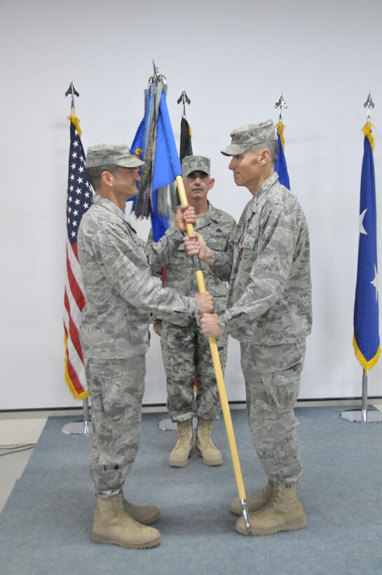 Maj. Gen. Russ Handy, 9th Air and Space Expeditionary Task Force-Iraq commander, and Air Component Coordination Element-Iraq director, accepts the guidon for the 332nd Air Expeditinary Wing from Brig. Gen. Kurt Neubauer at the relinquishment of command ceremony for the 332nd Air Expeditionary Wing at an undisclosed location in Southwest Asia Dec. 4, 2011. The ceremony marked the close of Neubauer's command over the 332nd AEW "Red Tails" who transitioned to this undisclosed location from Joint Base Balad, Iraq. (U.S. Air Force photo by Master Sgt. Paul Mann)