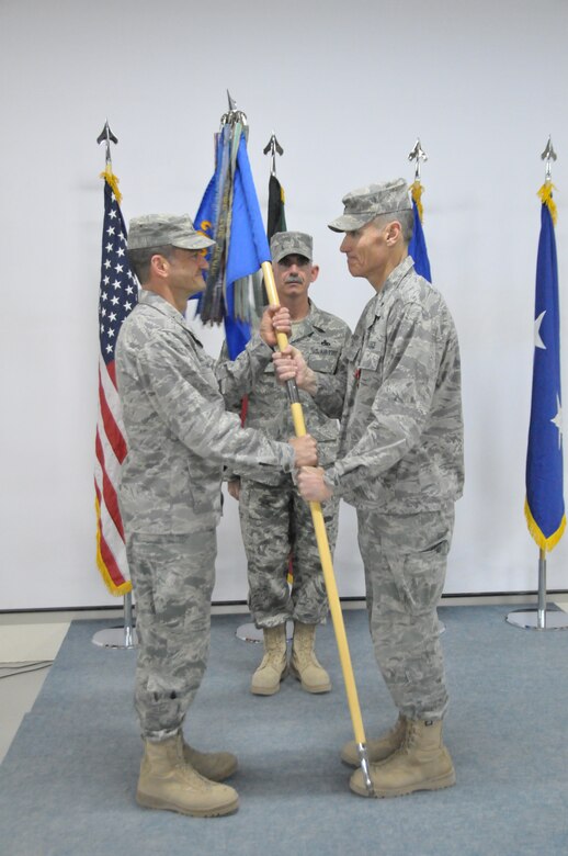 Maj. Gen. Russ Handy, 9th Air and Space Expeditionary Task Force-Iraq commander, and Air Component Coordination Element-Iraq director, accepts the guidon for the 332nd Air Expeditinary Wing from Brig. Gen. Kurt Neubauer at the relinquishment of command ceremony for the 332nd Air Expeditionary Wing at an undisclosed location in Southwest Asia Dec. 4, 2011. The ceremony marked the close of Neubauer's command over the 332nd AEW "Red Tails" who transitioned to this undisclosed location from Joint Base Balad, Iraq. (U.S. Air Force photo by Master Sgt. Paul Mann)