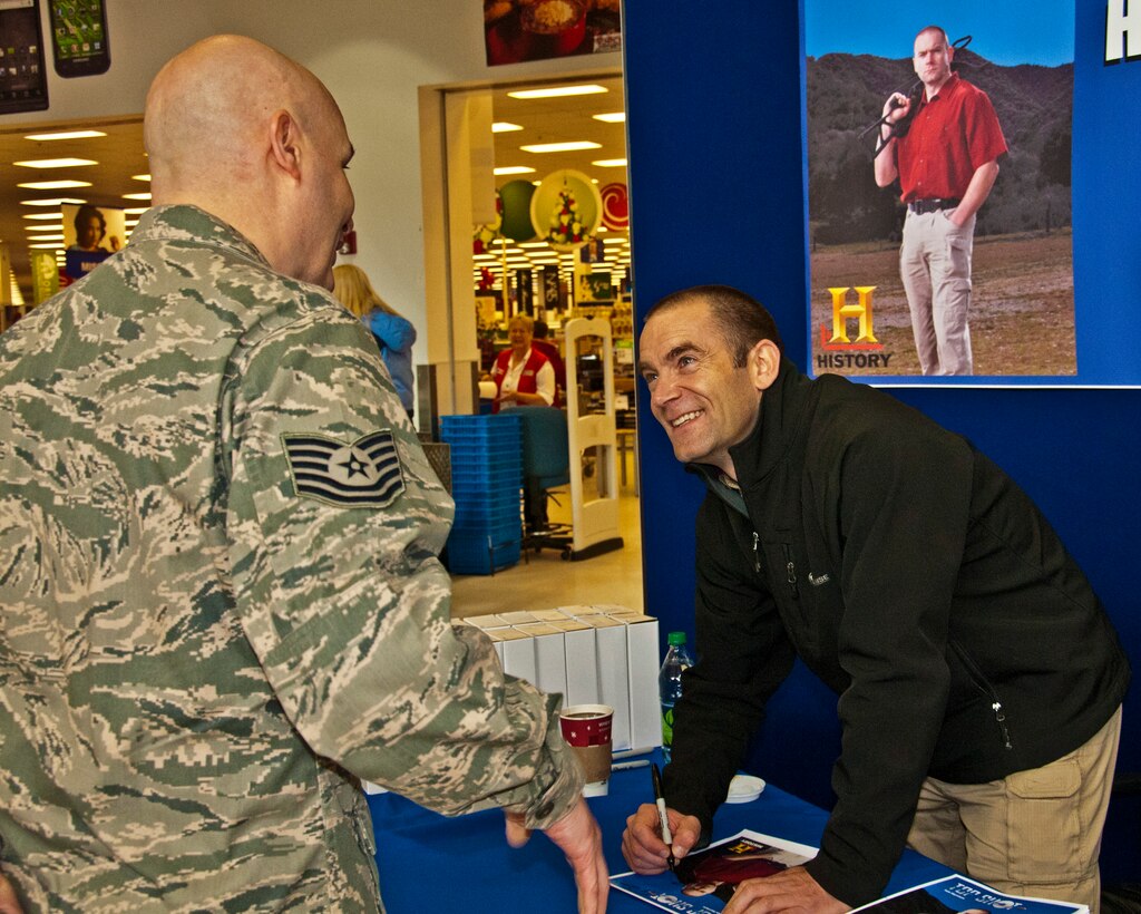 Iain Harrison, the first season winner of the History Channel's "Top Shot," signs an autograph for Tech. Sgt. James Callahan, 446th Aircraft Maintenance Squadron, Dec. 3, 2011 at the base exchange at Joint Base Lewis-McChord, Wash. Harrison first set foot on McChord Field as a member of the British Army twenty years earlier and returned to take his Oath of Allegiance to become an American citizen.  He also visited with military members and their families.  (U.S. Air Force photo by Tech. Sgt. Tanya King/Released)