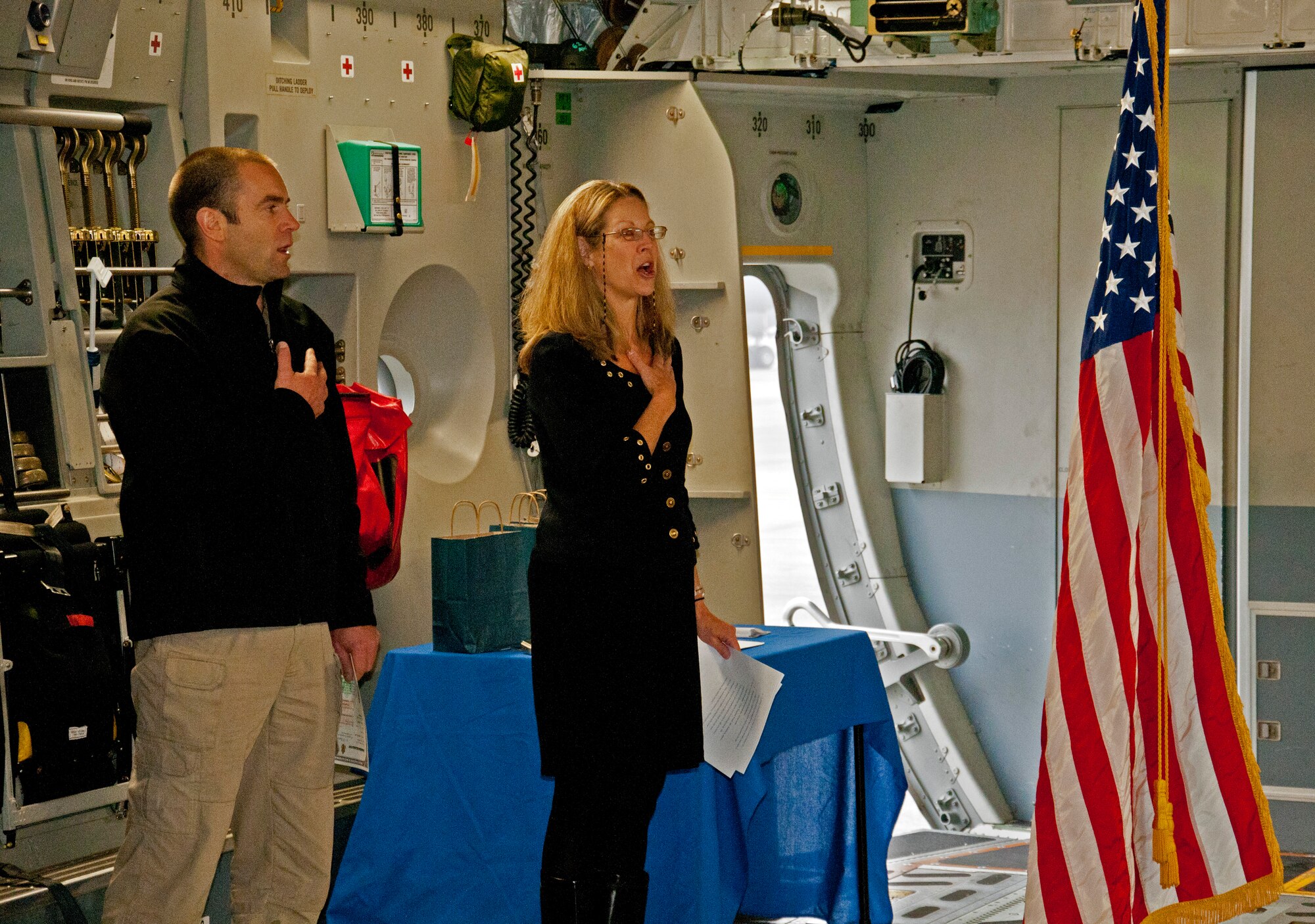 Iain Harrison, the first season winner of the History Channel's "Top Shot," and Anne Arries Corsano, USCIS District 20 district director, recite the Pledge of Allegiance aboard a C-17 Globemaster III Dec. 3, 2011 at Joint Base Lewis-McChord, Wash. Harrison first set foot on McChord Field as a member of the British Army twenty years earlier and returned to a ceremony to become an American citizen.  (U.S. Air Force photo by Tech. Sgt. Tanya King/Released)
