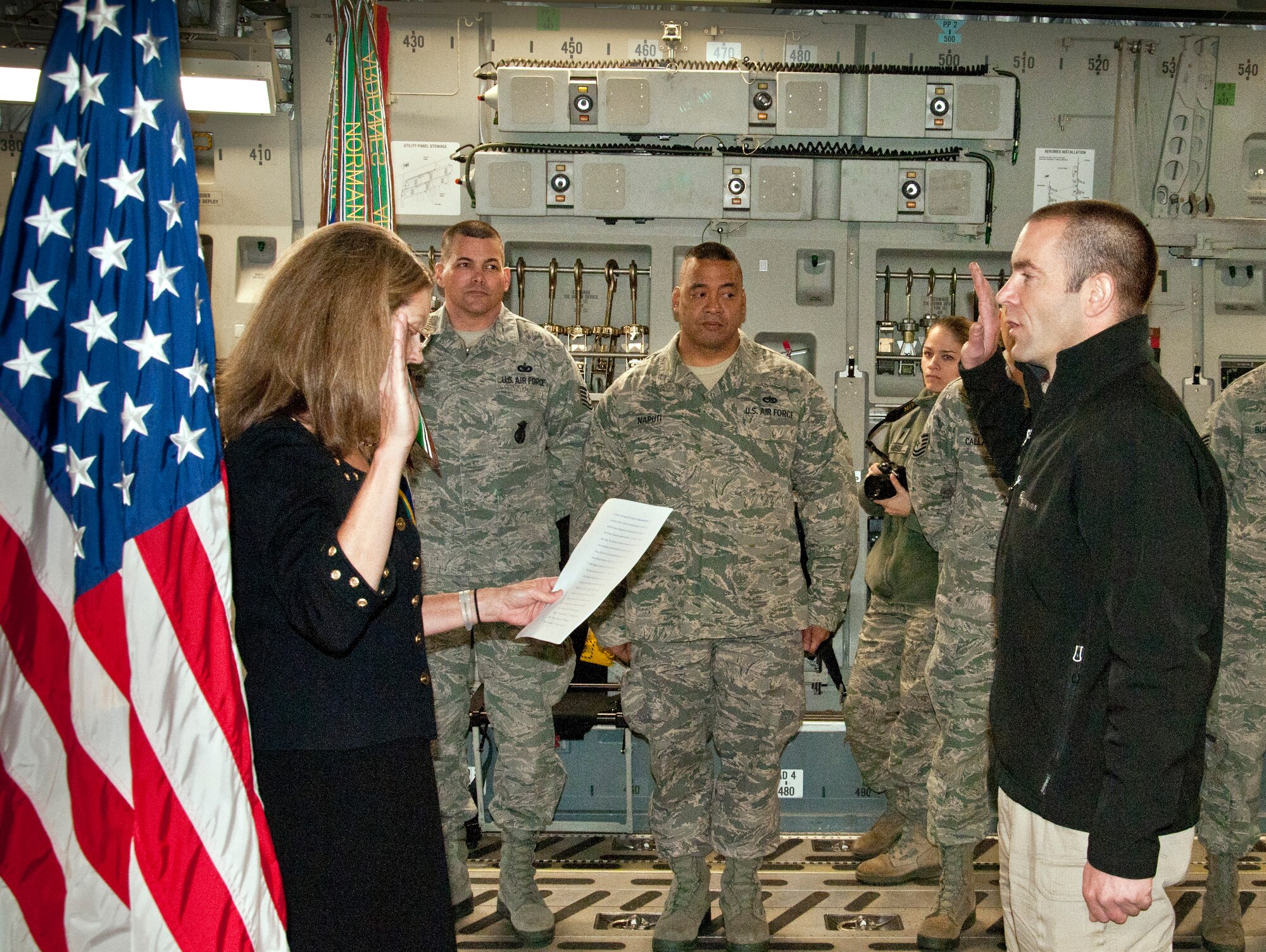 Iain Harrison, the first season winner of the History Channel's "Top Shot," and Anne Arries Corsano, USCIS District 20 district director, recite the Pledge of Allegiance aboard a C-17 Globemaster III Dec. 3, 2011 at Joint Base Lewis-McChord, Wash. Harrison first set foot on McChord Field as a member of the British Army twenty years earlier and returned to a ceremony to become an American citizen.  (U.S. Air Force photo by Tech. Sgt. Tanya King/Released)