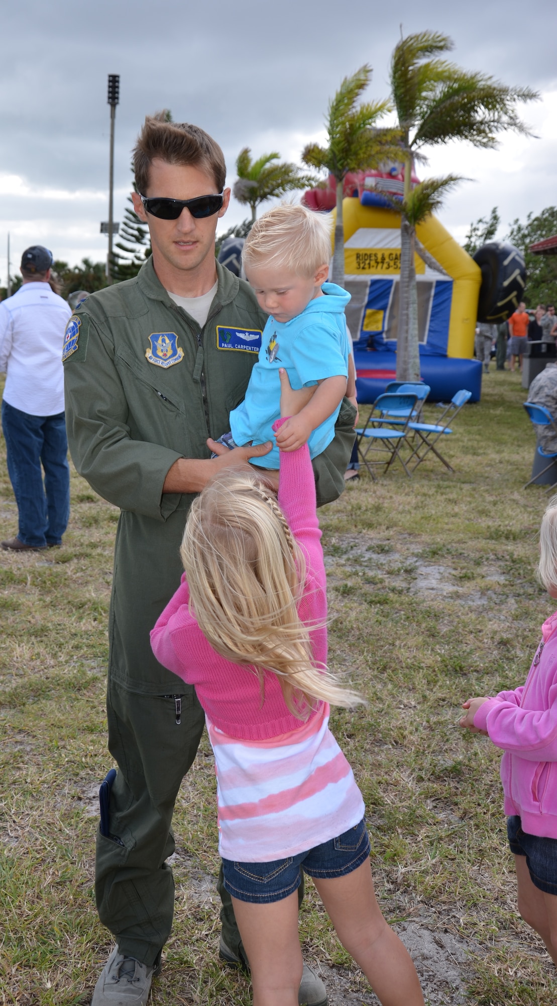 PATRICK AIR FORCE BASE, Fla.- Capt. Paul Carpenter, HH-60G Pave Hawk helicopter pilot holds on tight to his son while his daguhter plays with him. The Carpenters joined other reservists and their families at the family holiday picnic at Chevron Park here Dec. 3. (U.S. Air Force photo/Staff Sgt. Anna-Marie Wyant)