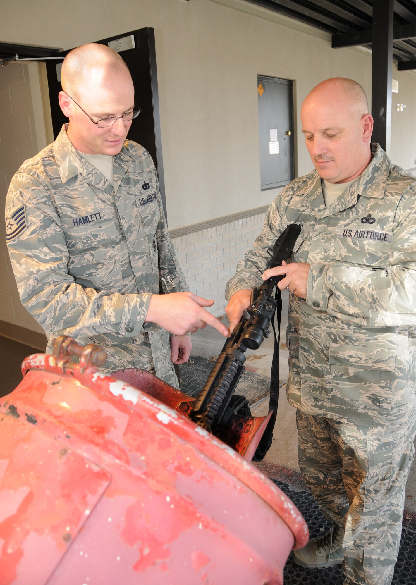 Master Sgt. Rob Kelley, right, clears his M-4 rifle as Tech. Sgt. Timothy Hamlett ensures there is not a bullet in the chamber during the Unit Training Assemble at Dover Air Force Base, Del., Nov. 6, 2011. The sergeants are reservists with the 512th Security Forces Squadron. Kelley saved a woman from carbon-monoxide poisoning and a fellow unit member from choking. (U.S. Air Force photo by Capt. Marnee A.C. Losurdo)