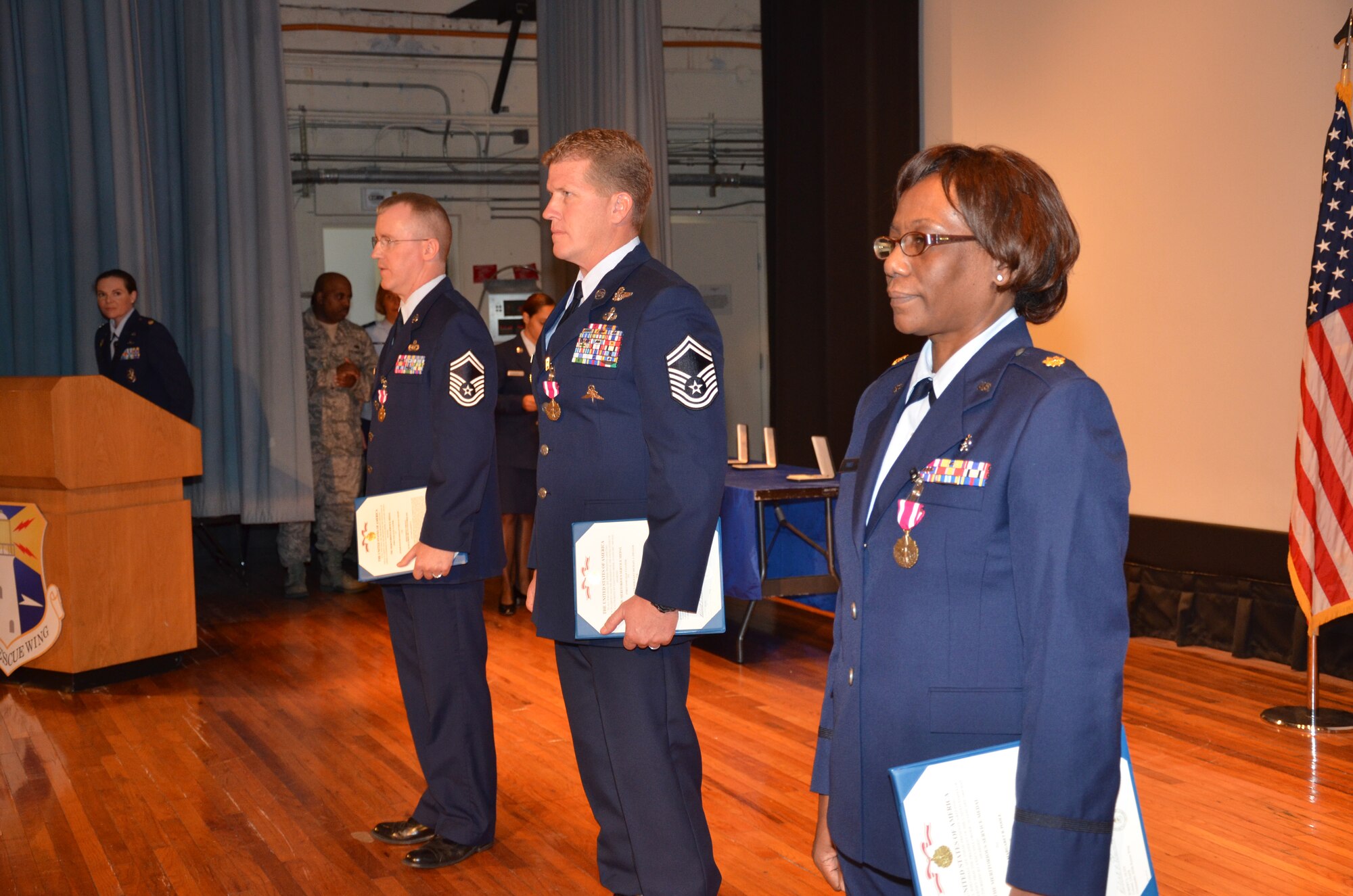 PATRICK AIR FORCE BASE, Fla.- Senior Master Sgts. Odean Lebahn, Michael Ziegler and Maj. Margaret Poole stand before their fellow Airmen after being awarded medals by the wing commander, Col. Jeffrey Macrander. The 920th Rescue Wing trains and equips over 1,700 Airmen to locate and recover U.S. Armed Forces personnel during military operations. (U.S. Air Force photo/Capt. Ryan Liss)
