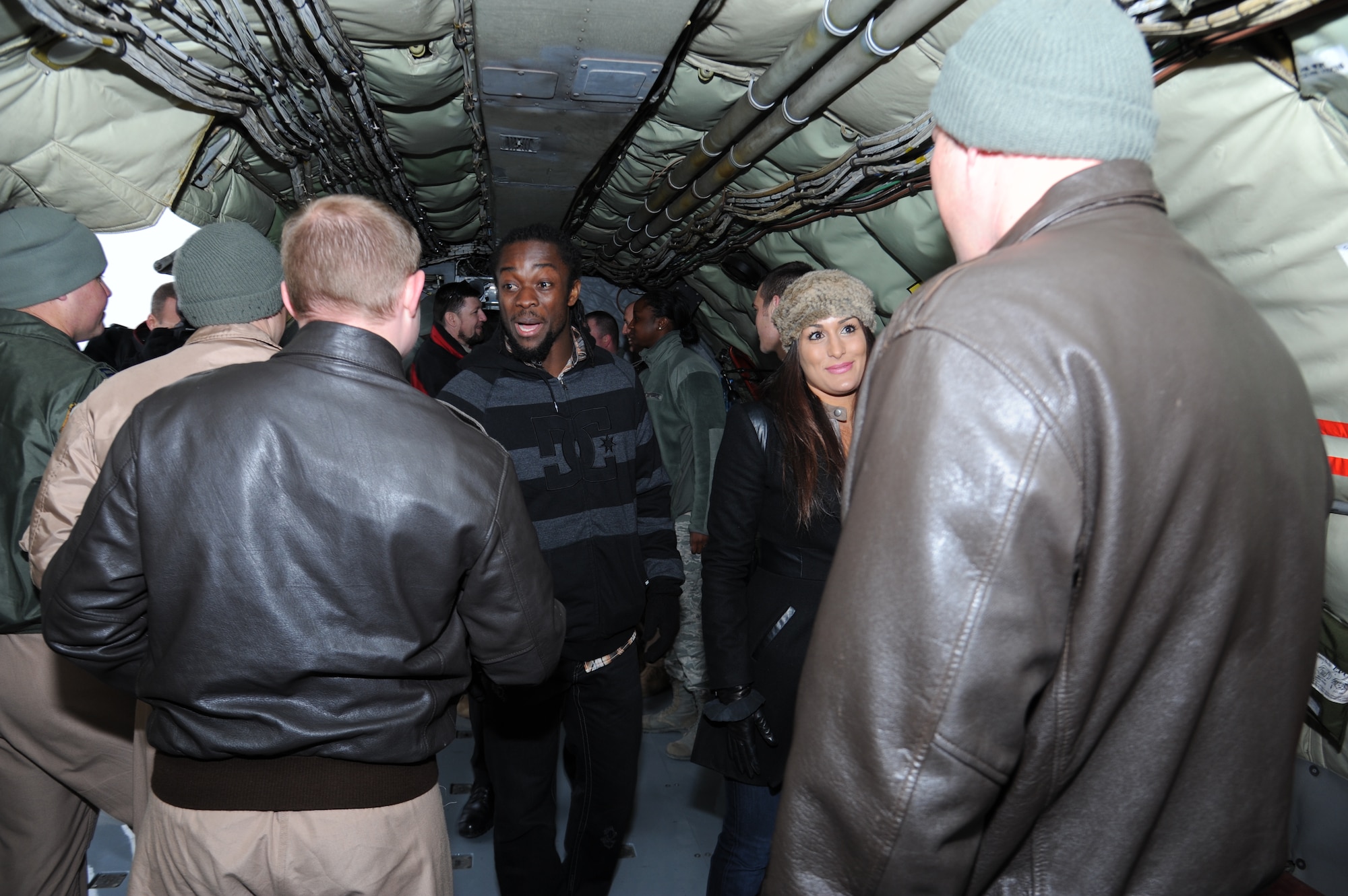 Kofi Kingston, World Wrestling Entertainment wrestler, (left) and Nikki Bella, WWE diva, greet service members while touring a KC-135 Stratotanker at the Transit Center at Manas, Kyrgyzstan, Dec. 2. Armed Forces Entertainment hosts more than 1,200 shows around the world each year, reaching more than 500,000 personnel at 270 military installations. (U.S. Air Force photo/Tech. Sgt. Hank Hoegen)