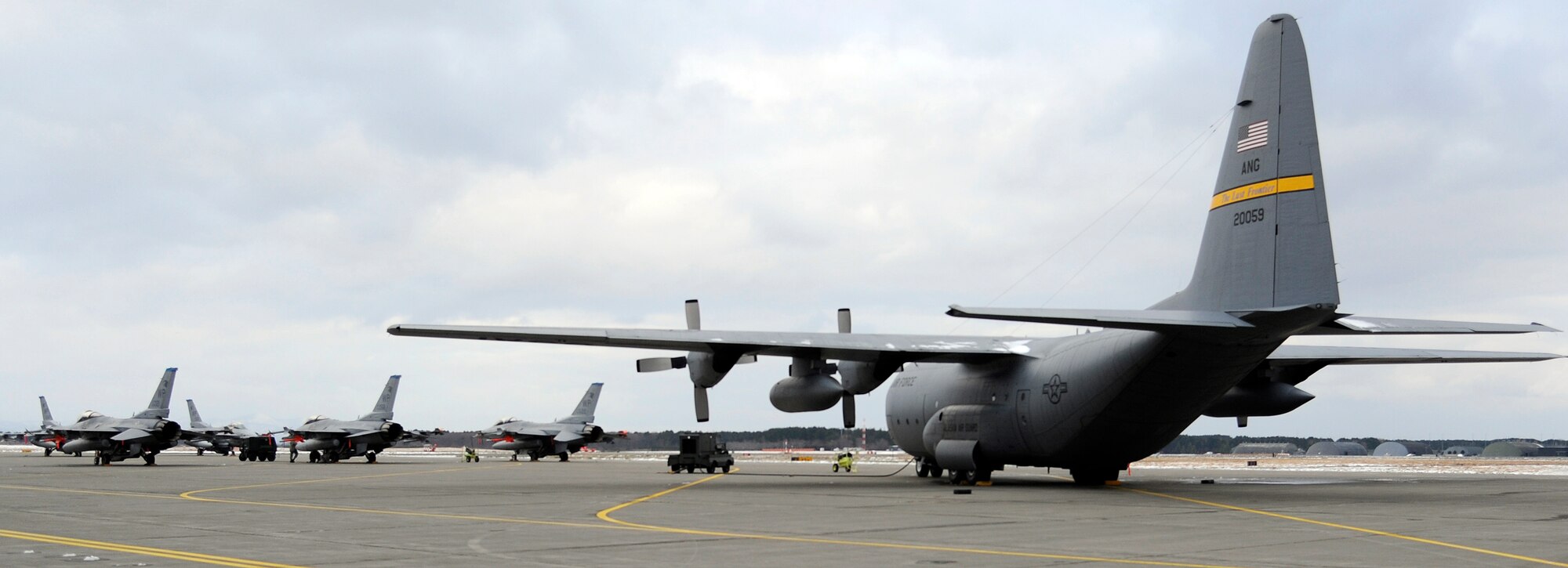 MISAWA AIR BASE, Japan - A C-130 from the Alaska National Guard and eight F-16s with the 35th Fighter Squadron out of Kunsan Air Base, Korea, sit postured on the flightline here awaiting participation as aggressors during an operational readiness inspection here Dec. 6. The 35th Fighter Wing from Misawa is currently going through an ORI which occur every two years. The Pacific Air Forces Inspector General Team will spend this week evaluating the deployment capabilities of Misawa's airmen. (U.S. Air Force photo/Tech. Sgt. Marie Brown)
