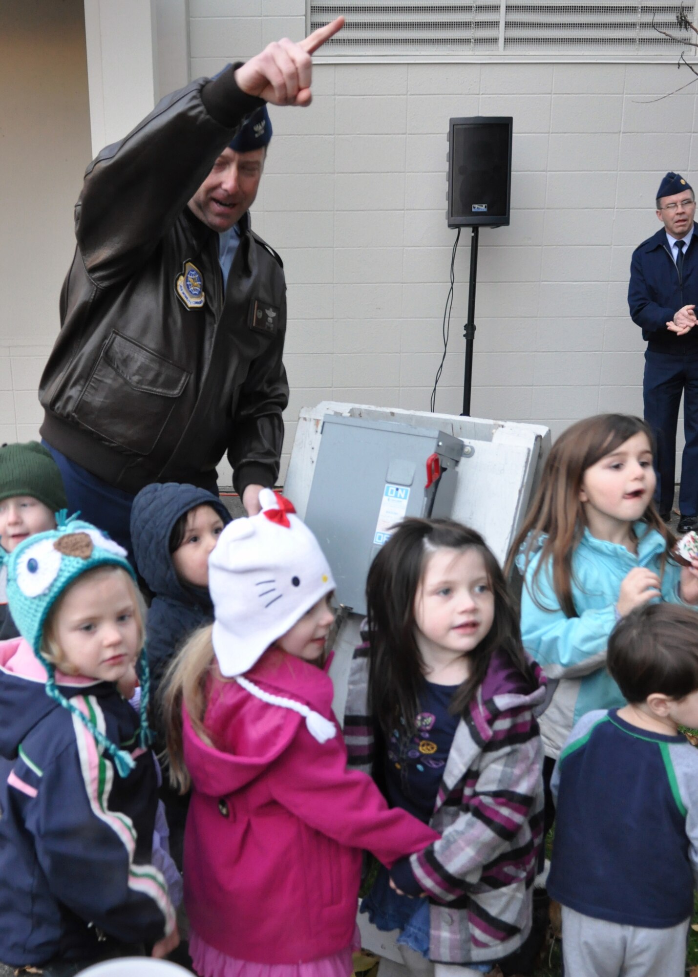 Col. Wyn Elder, 62nd Airlift Wing commander, helps children pull a power switch to turn on the lights of a decorated holiday tree during the McChord Field annual tree lighting ceremony Dec. 5, 2011, at Joint Base Lewis-McChord, Wash. (U.S. Air Force photo/Airman 1st Class Leah Young)