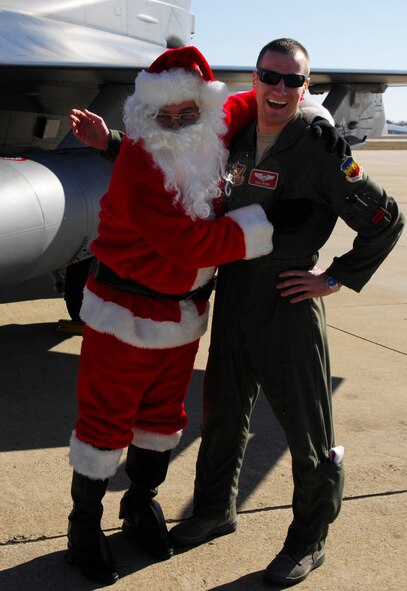 U.S. Air Force 2nd Lt. Daniel Wynn, 77th Fighter Squadron, greats Santa after his arrival to Shaw in an F-16 Fighting Falcon at the 20th Operations Group Christmas Party, Shaw Air Force Base, S.C. Dec. 3, 2011.   (U.S. Air Force photo by Airman 1st Class Ashley L. Gardner/ Released)