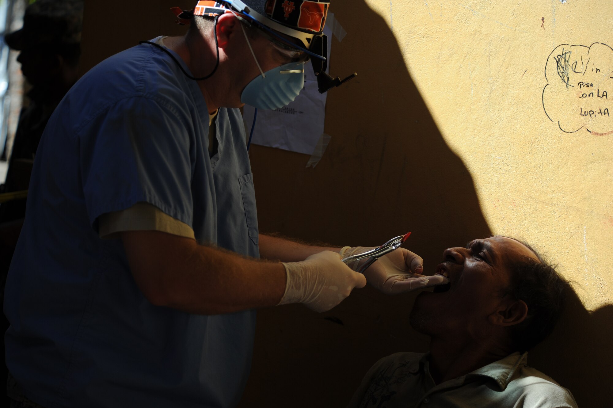 Maj. David Dennison, a Joint Task Force-Bravo Medical Element general dentist, pulls a tooth of a Honduran man during a Medical Readiness Training Exercise Nov. 29, 2011, at a school in Choluteca, Honduras.  By the end of the two-day mission, the U.S. and Honduran medical staff combined achievements included the assistance of nearly 150 dental patients, the filling of more than 2000 pharmacy prescriptions, and the education of over 1,100 people in preventative medicine. (U.S. Air Force photo/Tech. Sgt. Matthew McGovern)       