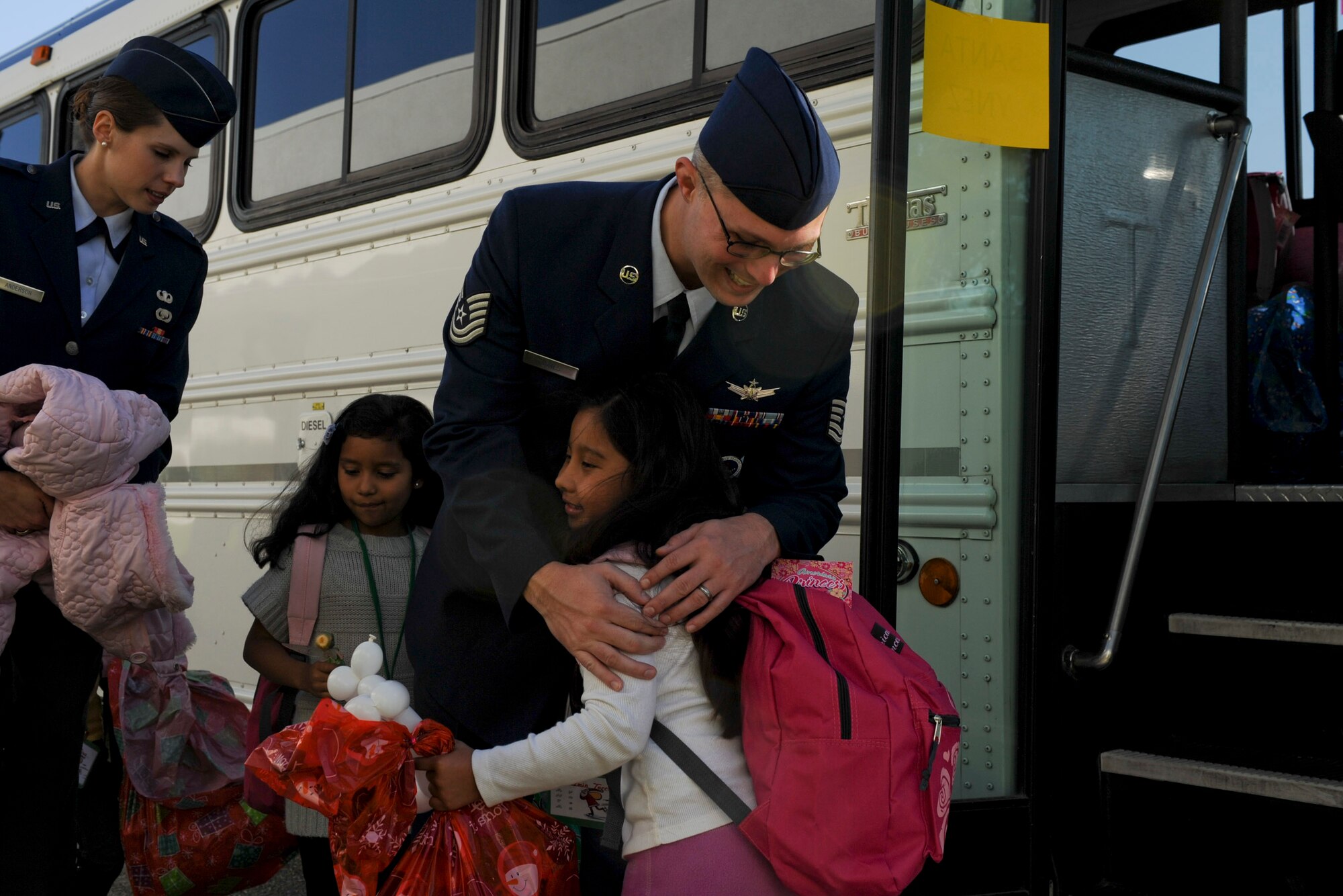 VANDENBERG AIR FORCE BASE, Calif. --Tech. Sgt. David Jones hugs Jasmine, age 7 from the Santa Ynez Valley, goodbye after the festivities of Operation Kids Christmas at the Pacific Coast Club here Saturday, Dec. 3, 2011. OKC is an annual event, organized and run by a private organization, in which approximately 200 local children are brought on base and given the opportunity to play games, meet Santa and enjoy the companionship of volunteer military members. (U.S. Air Force/Staff Sgt. Levi Riendeau)