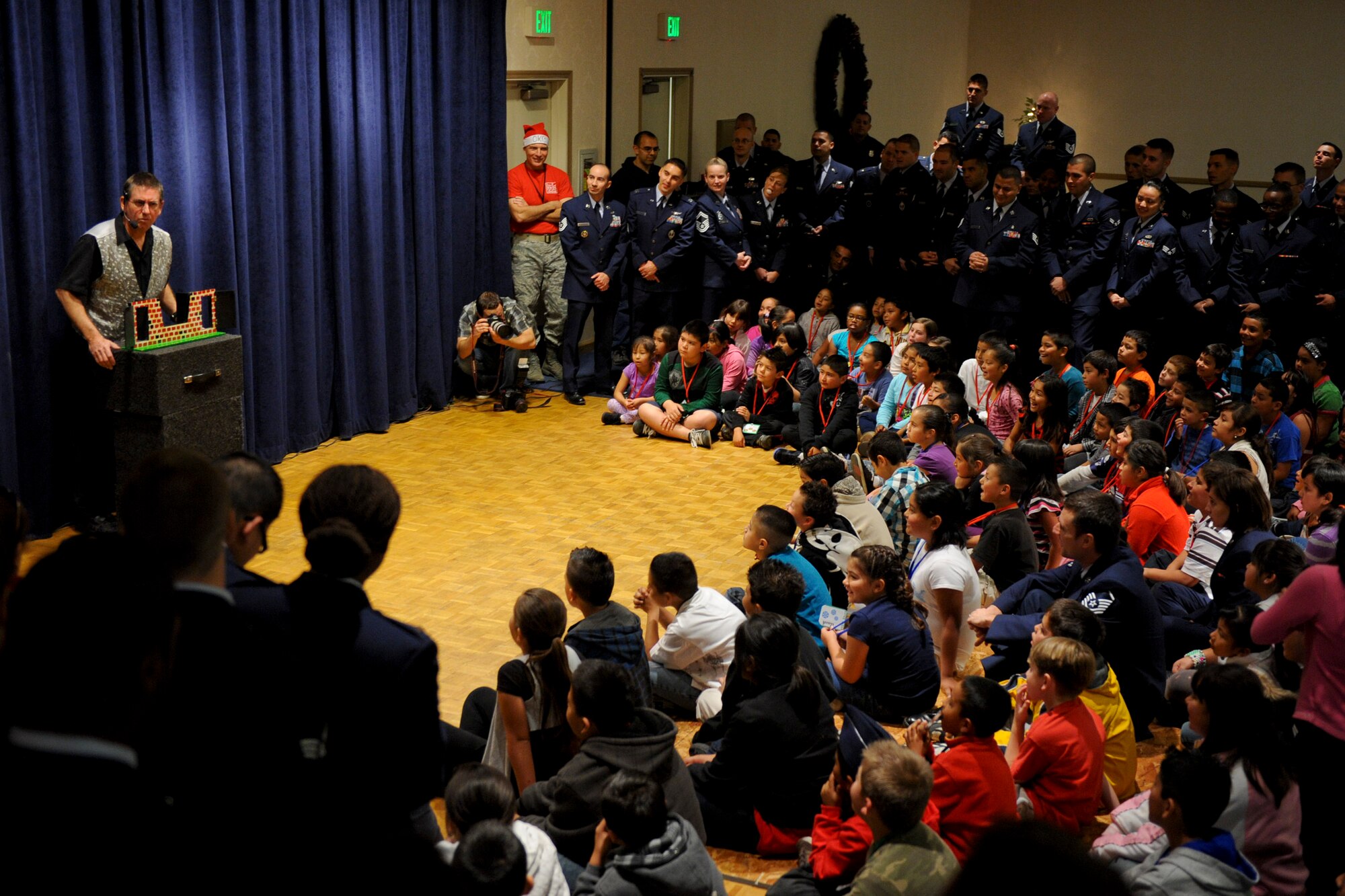 VANDENBERG AIR FORCE BASE, Calif. --A local magician performs magic in front of a crowd of children from the local community during Operation Kids Christmas at the Pacific Coast Club here Saturday, Dec. 3, 2011. OKC is an annual event, organized and run by a private organization, in which approximately 200 local children are brought on base and given the opportunity to play games, meet Santa and enjoy the companionship of volunteer military members. (U.S. Air Force/Staff Sgt. Levi Riendeau)