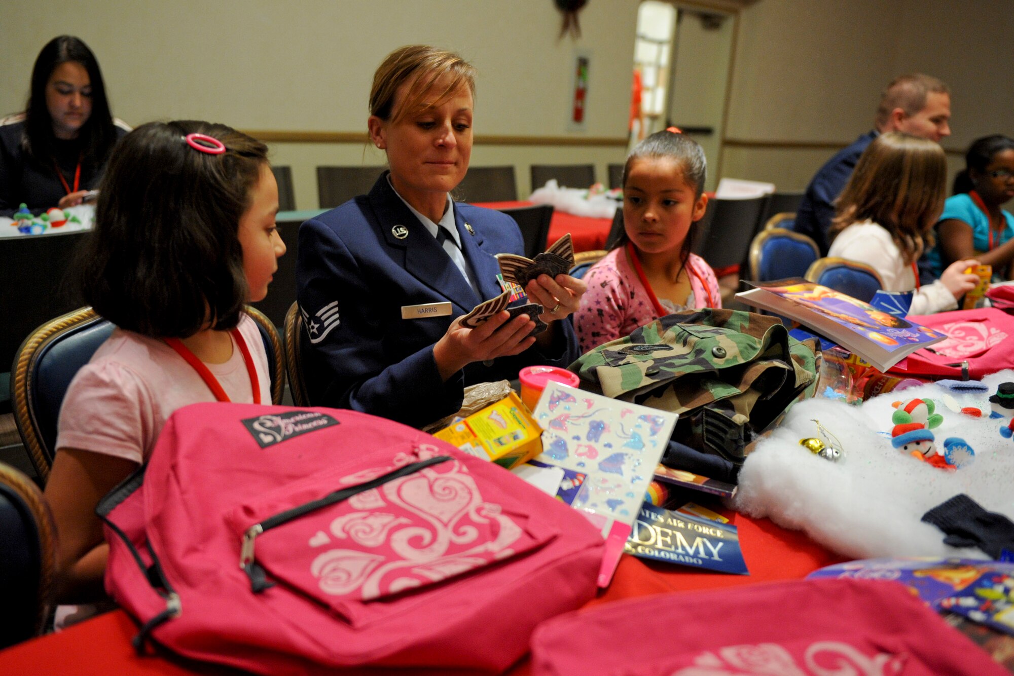 VANDENBERG AIR FORCE BASE, Calif. -- Staff Sgt. Joscelyn Harris shows off various patches and items from her career while waiting for the next event during Operation Kids Christmas at the Pacific Coast Club here Saturday, Dec. 3, 2011. OKC is an annual event, organized and run by a private organization, in which approximately 200 local children are brought on base and given the opportunity to play games, meet Santa and enjoy the companionship of volunteer military members. (U.S. Air Force/Staff Sgt. Levi Riendeau)