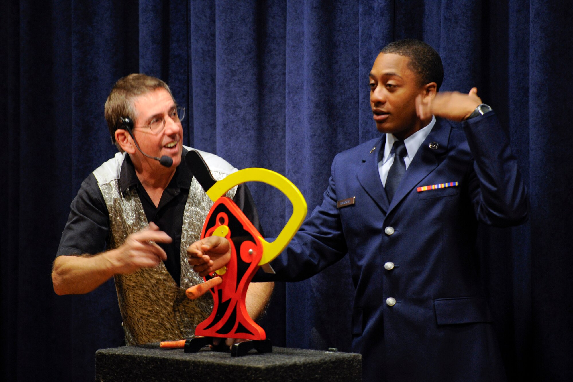 VANDENBERG AIR FORCE BASE, Calif. -- Nervous over the possibility of losing a hand, Airman Shaquille Hargrove fans his face while a local magician gets ready to cut two carrots without harming Hargrove during Operation Kids Christmas at the Pacific Coast Club here Saturday, Dec. 3, 2011. OKC is an annual event, organized and run by a private organization,  in which approximately 200 local children are brought on base and given the opportunity to play games, meet Santa and enjoy the companionship of volunteer military members. (U.S. Air Force/Staff Sgt. Levi Riendeau)
