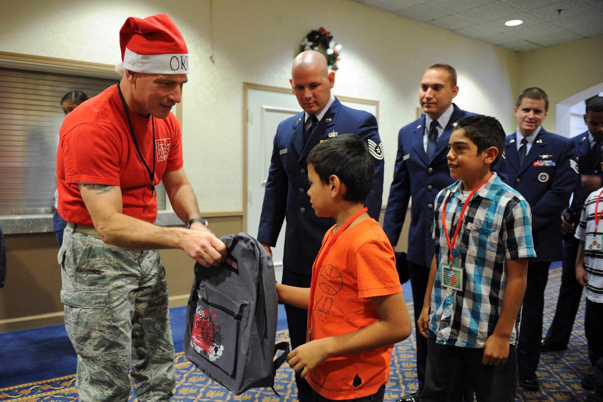 VANDENBERG AIR FORCE BASE, Calif. -- Lt. Col. Michael Kamorski hands out backpacks full of goodies to local community children during Operation Kids Christmas at the Pacific Coast Club here Saturday, Dec. 3, 2011. OKC is an annual event, organized and run by a private organization,  in which approximately 200 local children are brought on base and given the opportunity to play games, meet Santa and enjoy the companionship of volunteer military members. (U.S. Air Force/Staff Sgt. Levi Riendeau)
