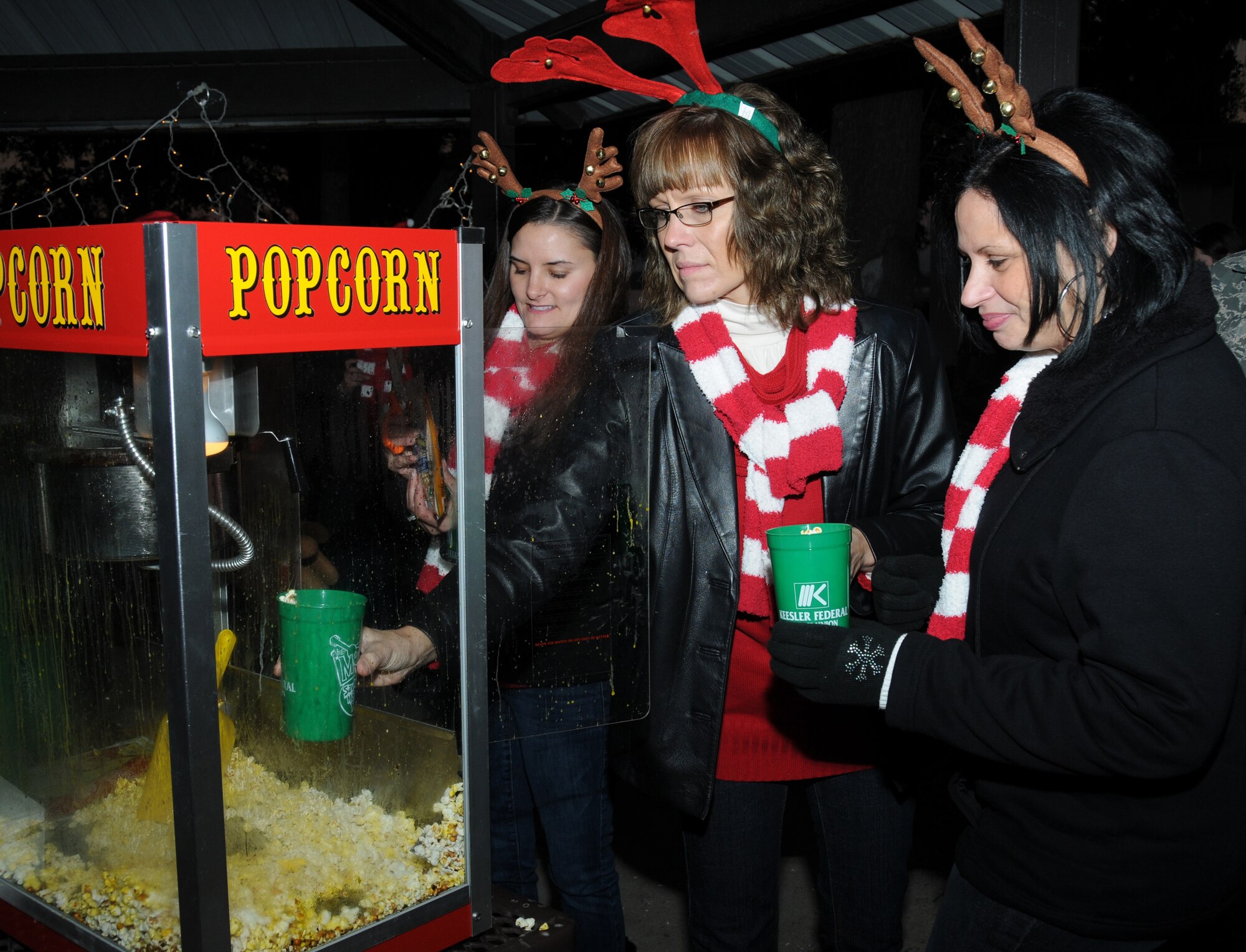 Jessica Bartels, Angela Rink and Germaine Lamey fill cups with pop corn for visitors at Keesler’s annual Holiday in the Park at the Marina Park, Keesler Air Force Base, Miss. Dec. 1, 2011.  The event included a tree lighting ceremony, hay rides, holiday music by the Keesler Choir, visit with Santa and free food and beverages.  (U.S. Air Force photo by Kemberly Groue)