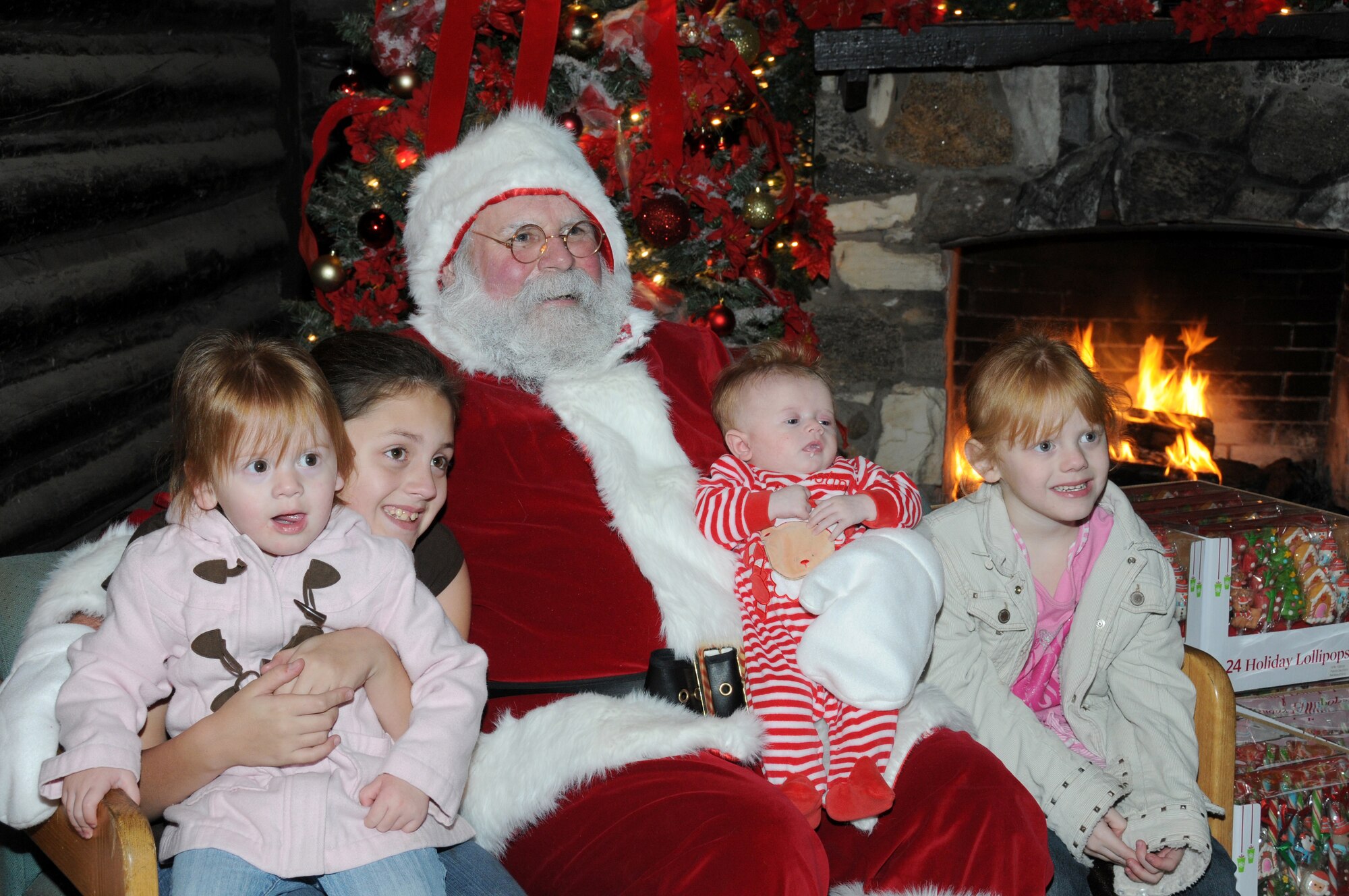Ainsley, 2; Kelsey, 11; Teagan, 3 months; and Aubrey, 5, dependants of Tech Sgt. Daniel and Katie Schumann, take a photo with Santa Claus during Keesler’s annual Holiday in the Park at the Marina Park, Keesler Air Force Base, Miss. Dec. 1, 2011.  The event included a tree lighting ceremony, hay rides, holiday music by the Keesler Choir, visit with Santa and free food and beverages.  (U.S. Air Force photo by Kemberly Groue)